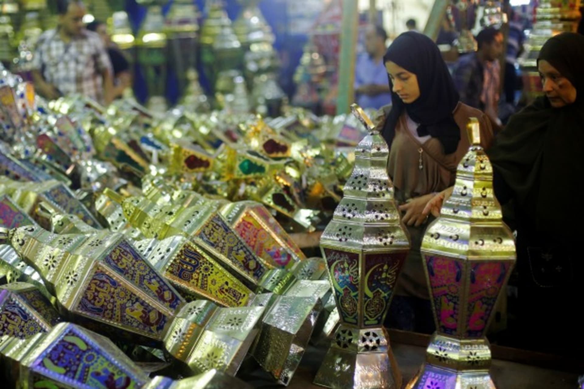 <p>A woman with her daughter look at a stall selling festival lights and Ramadan lanterns, or “fanoos Ramadan”, at Sayida Zienab district market during the first day of Ramadan in old Cairo, Egypt (Amr Abdallah Dalsh/Reuters).</p>
