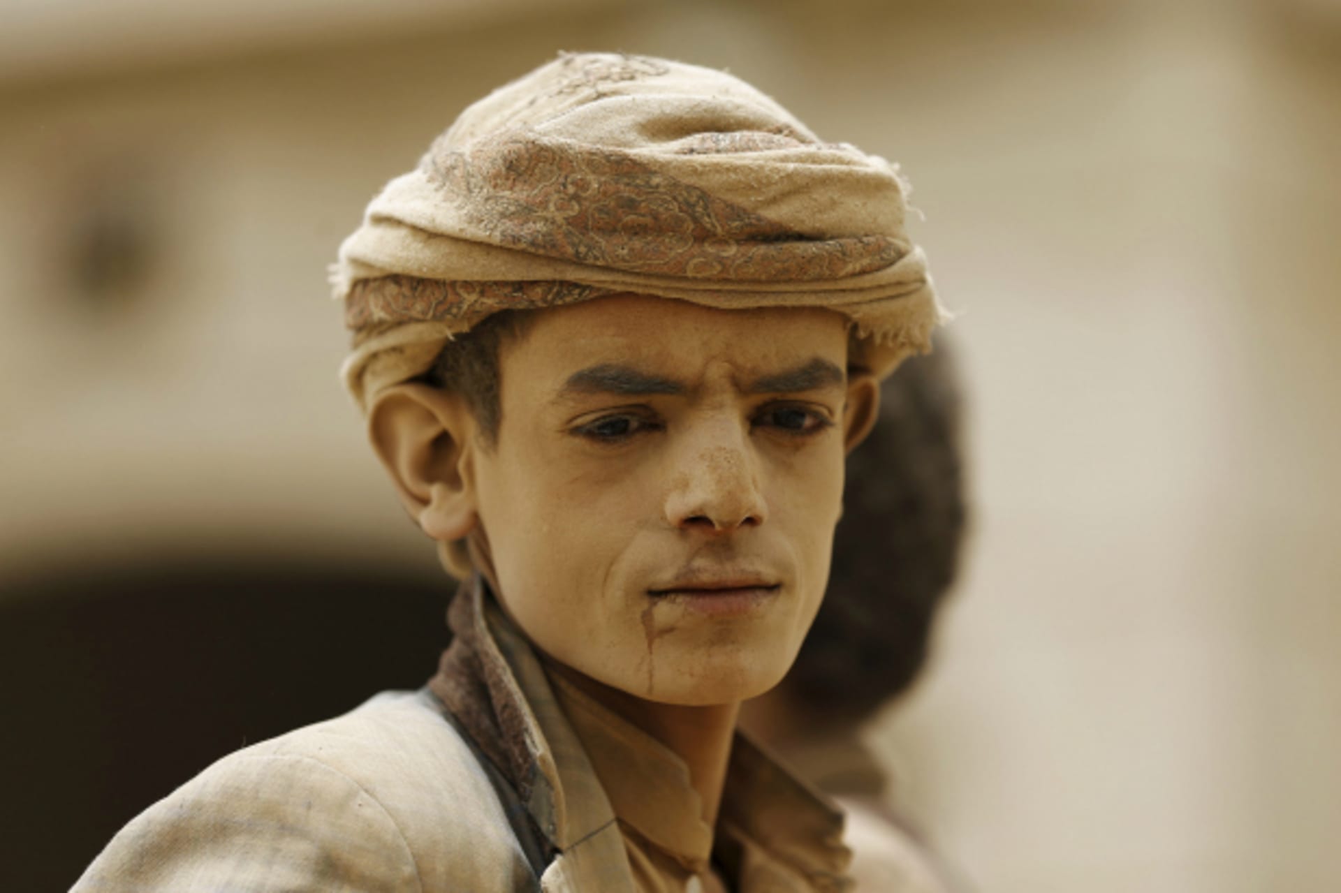 <p>A farm boy, with his face covered with sand, is pictured as he leaves the farm he works on, near Sanaa, Yemen (Khaled Abdullah/Reuters).</p>
