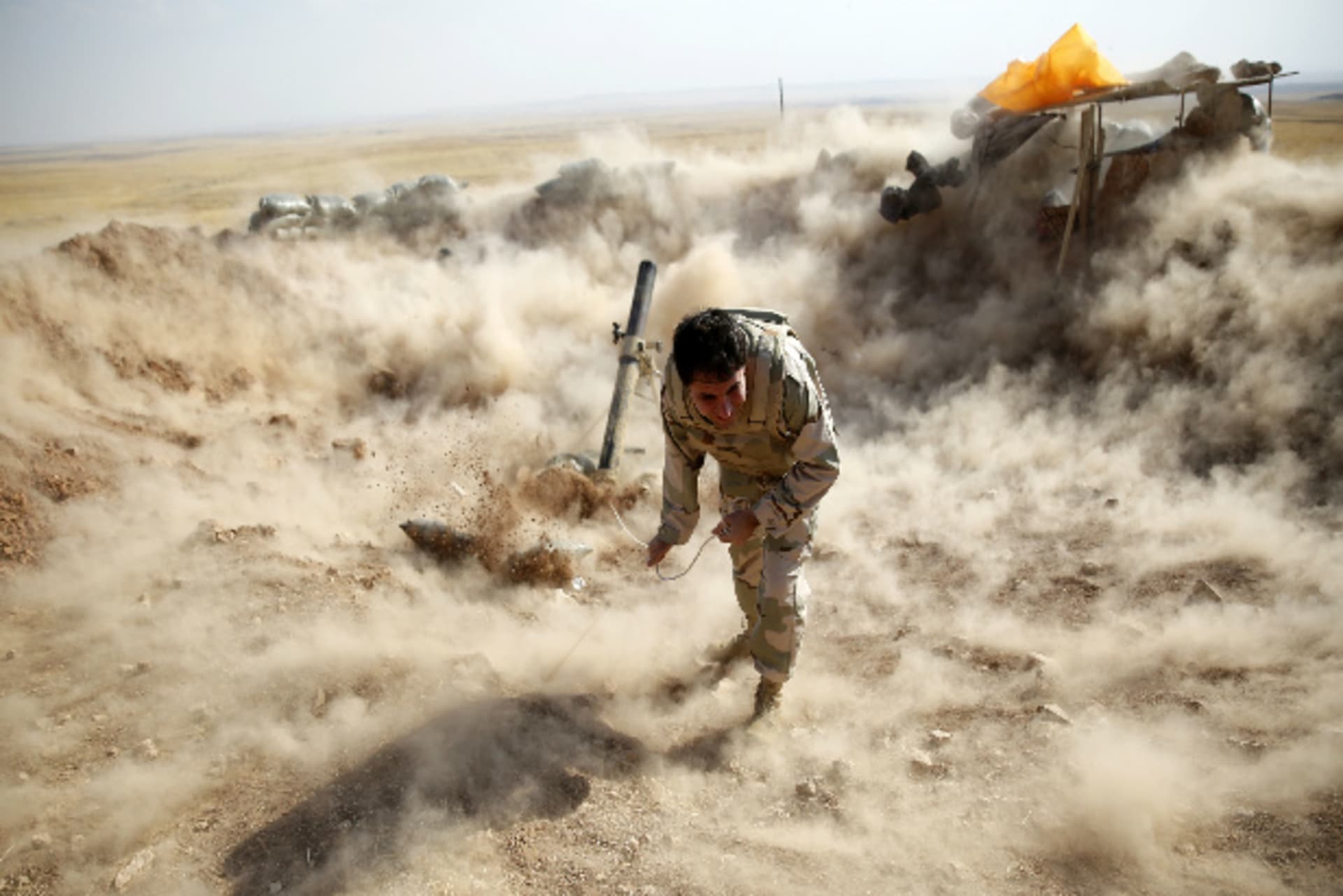 A Kurdish peshmerga fighter launches mortar shells (Jadallah/Courtesy Reuters).