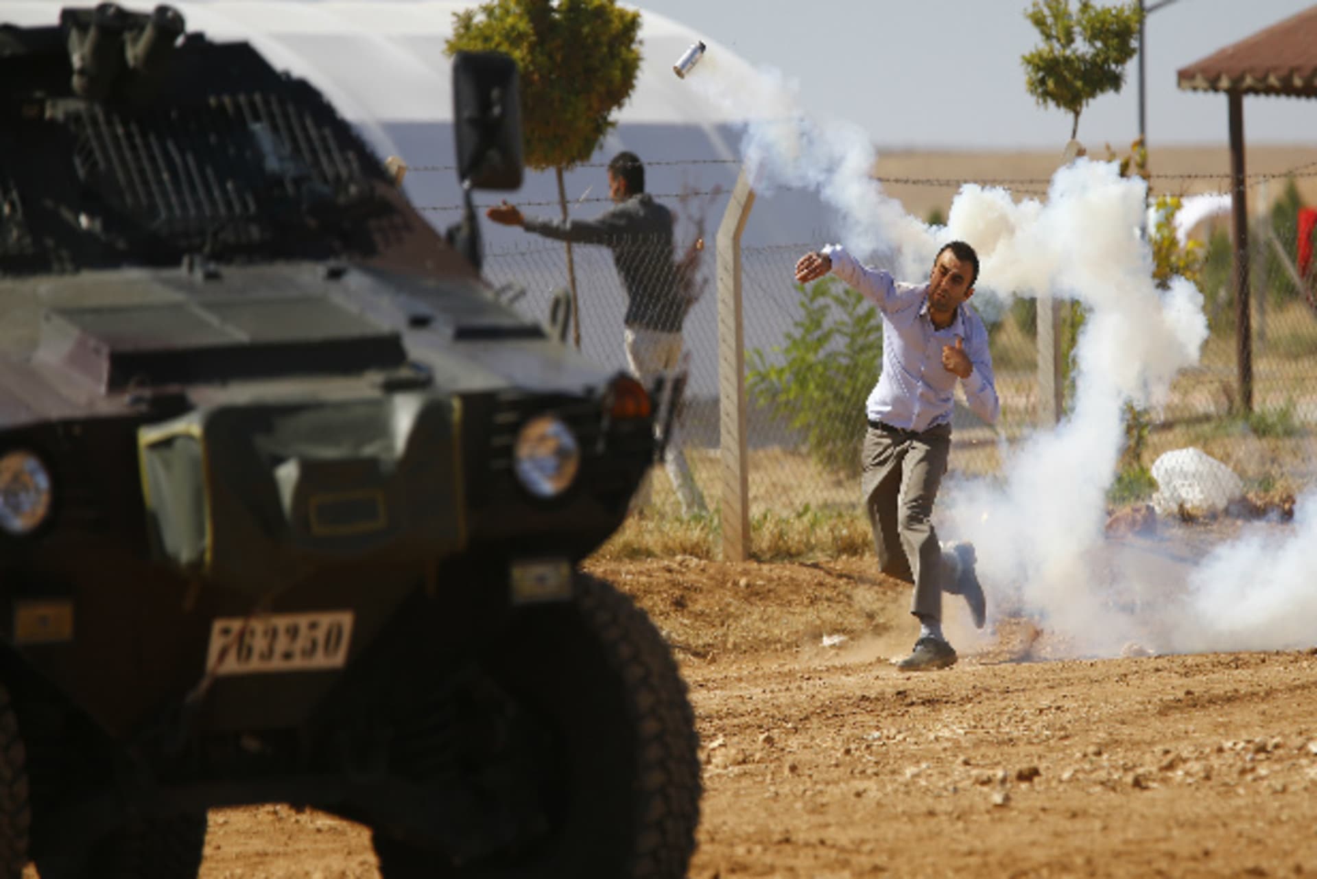 A Turkish Kurdish protester throws a tear gas canister back at Turkish soldiers near the Mursitpinar border crossing on the Turkish-Syrian border in the Turkish town of Suruc in southeastern Sanliurfa province October 4, 2014 (Sezer/Courtesy Re