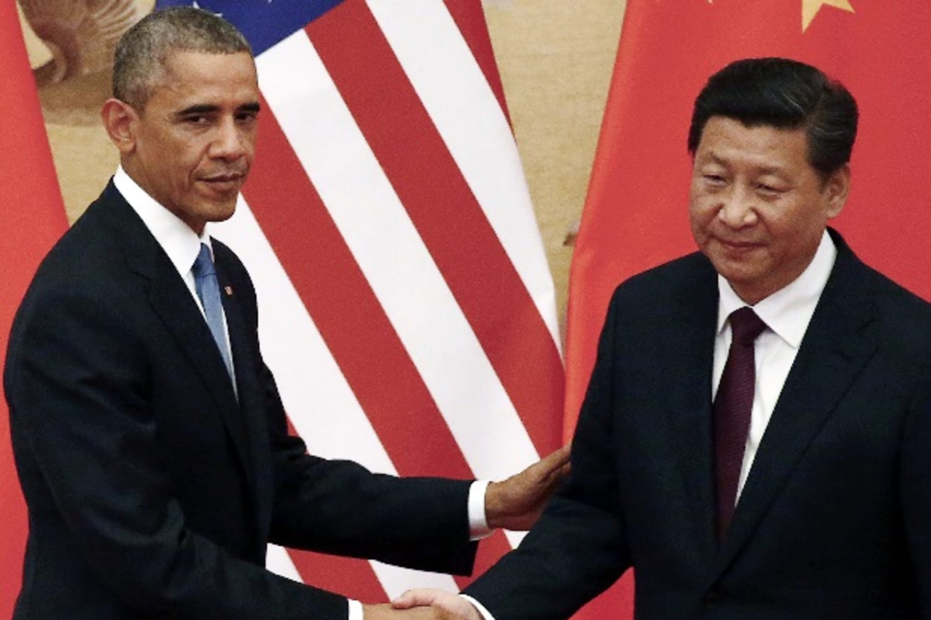 <p>U.S. President Barack Obama (L) shakes hands with China’s President Xi Jinping in front of U.S. and Chinese national flags during a joint news conference at the Great Hall of the People in Beijing November 12, 2014. REUTERS/Petar Kujundzic</p>
