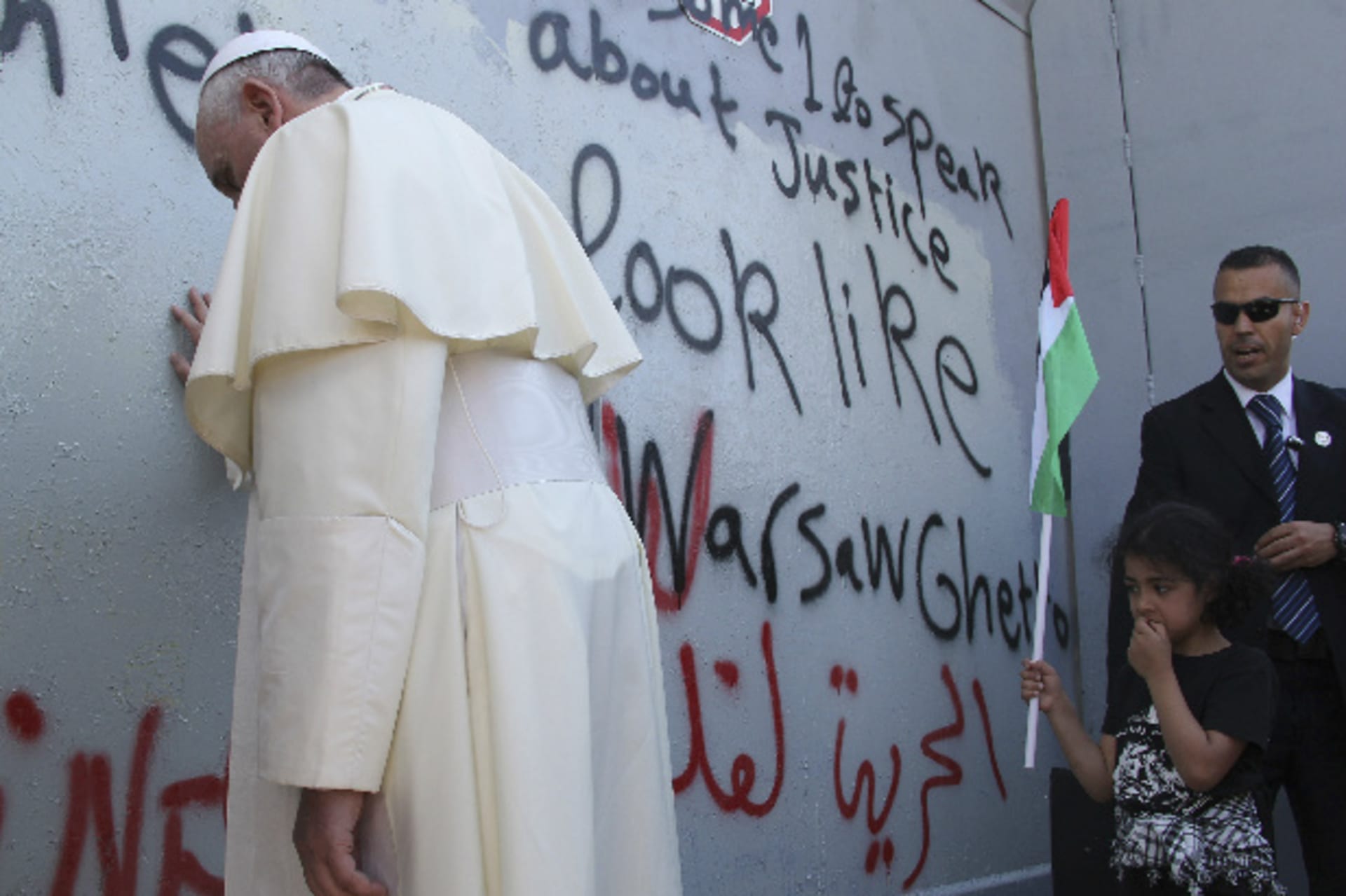 Pope Francis touches the wall that divides Israel from the West Bank, on his way to celebrate a mass in Manger Square next to the Church of the Nativity in the West Bank city of Bethlehem May 25, 2014 (Amareen/Courtesy Reuters).