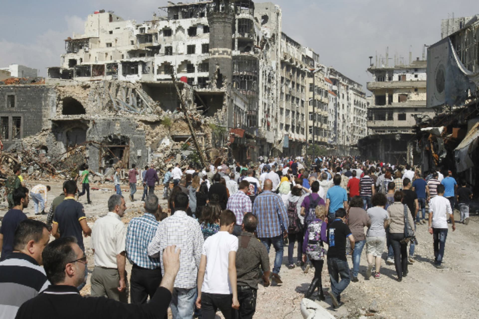Residents arrive on foot to inspect their homes in the al-Hamdeya neighborhood, after the cessation of fighting between rebels and forces loyal to Syria's president Bashar al-Assad, in Homs May 9, 2014 (al-Hariri/Courtesy Reuters).