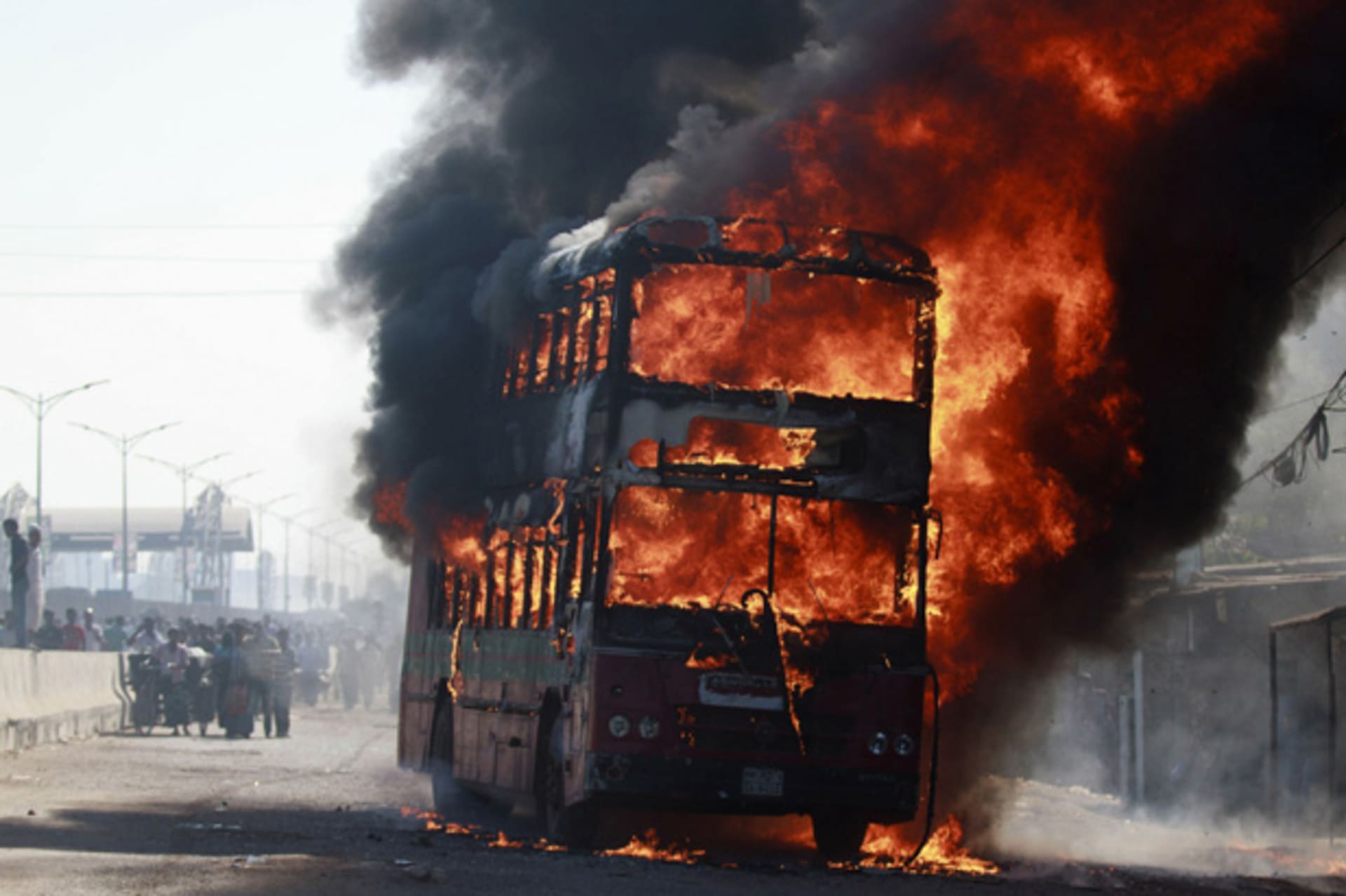 <p>Smoke rises as a bus burns on a street after a nationwide strike was called, in Dhaka November 9, 2013 (Mahmud Opu/Courtesy Reuters).</p>
