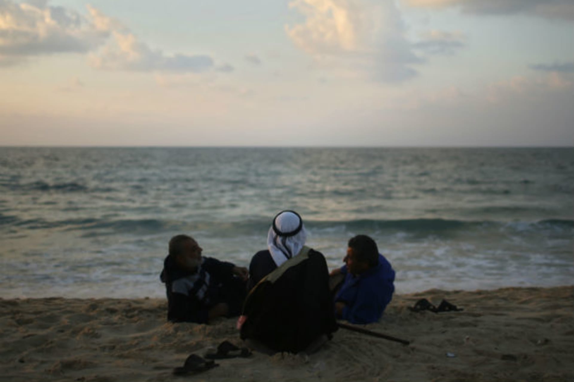 <p>Palestinians sit on the beach in Gaza City.</p>