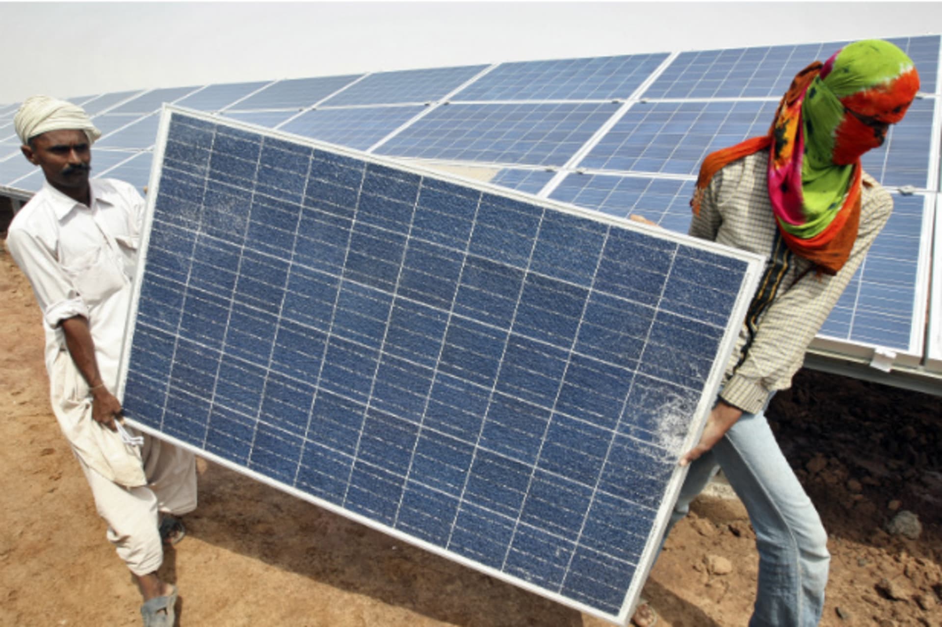 <p>Workers carry a damaged photovoltaic solar panel at the Gujarat solar park under construction in the Indian state of Gujarat (Reuters/Amit Dave).</p>