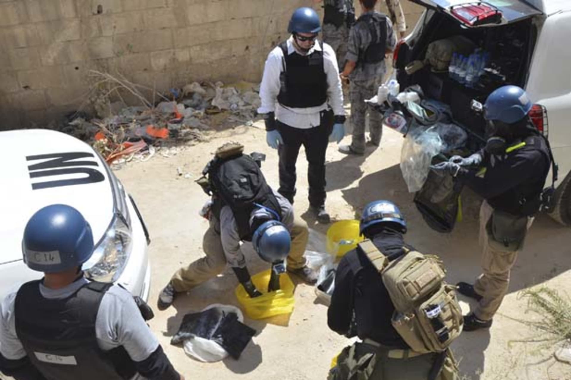 <p>UN chemical weapons experts prepare to collect samples from an alleged site of a chemical weapons attack in the Damascus suburb of Zamalka (Bassam Khabieh/Courtesy Reuters).</p>