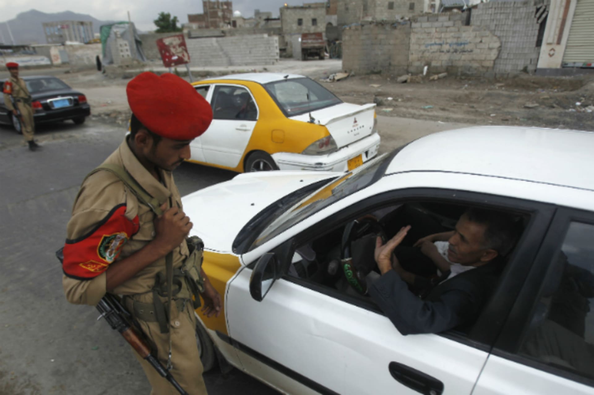 <p>A military police trooper checks a car at a checkpoint in Sanaa</p>

