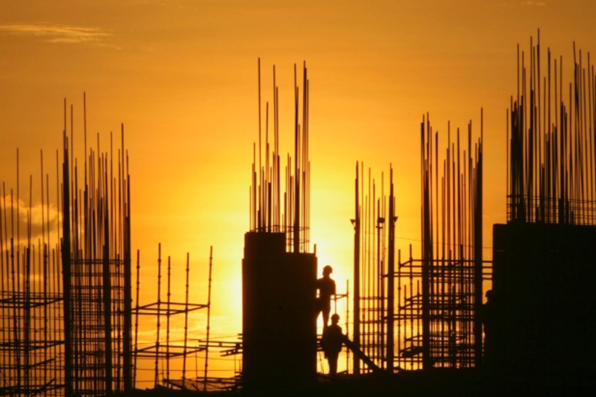 Labourers are silhouetted against the setting sun as they work at the construction site of a residential building in the southern Indian city of Hyderabad on October 5, 2012.