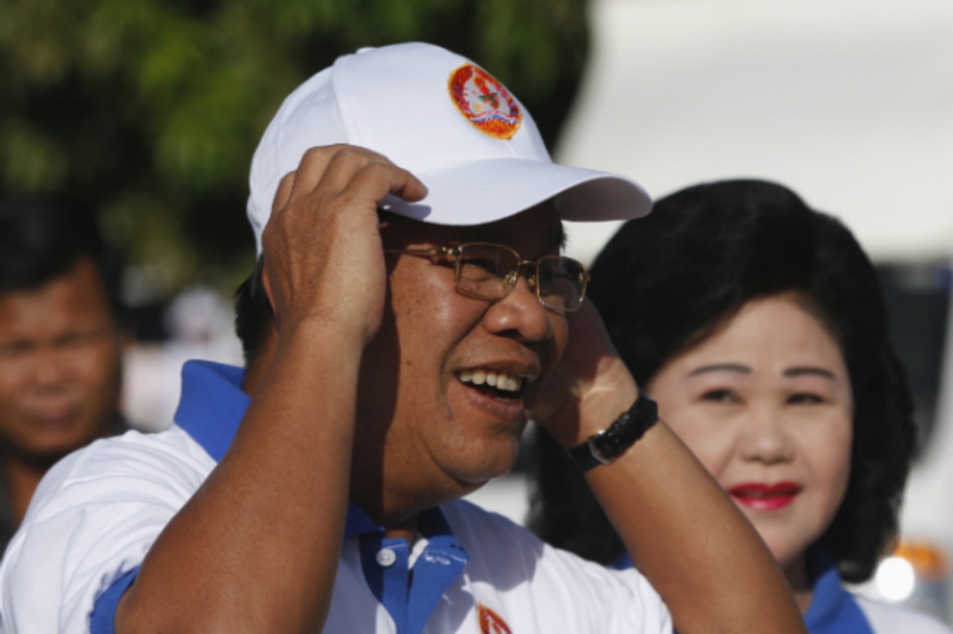 <p>Cambodia’s Prime Minister Hun Sen and his wife Bun Rany (R) arrive at an election campaign area in Phnom Penh on June 27, 2013. (Pring Samrang/Courtesy Reuters)</p>
