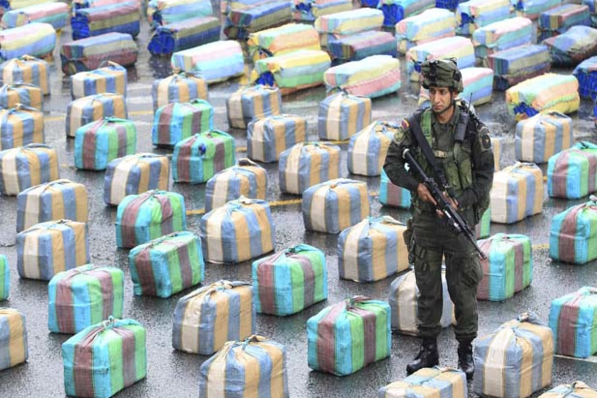 A Colombian police officer stands guard near packs of confiscated marijuana in Cali