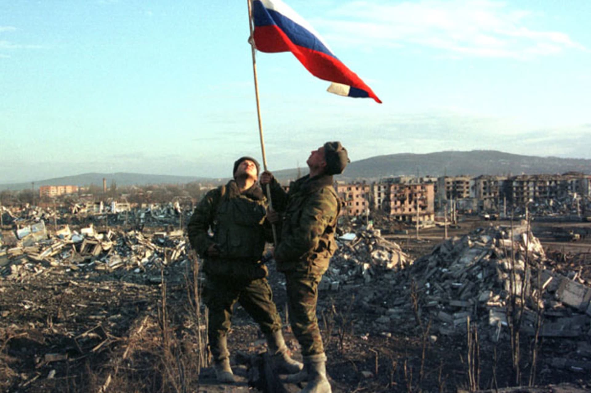 <p>Russian soldiers stand with a raised flag after an operation in the Chechen capital Grozny on February 27, 2000 (Courtesy Reuters).</p>