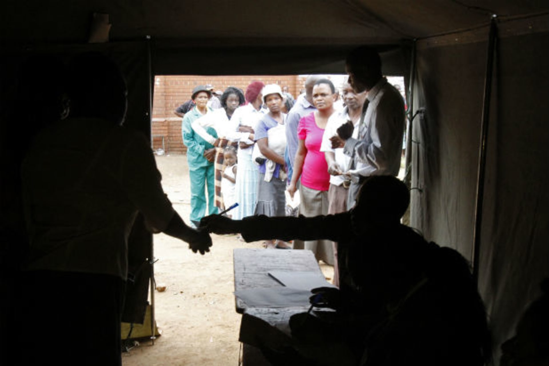 People queue to vote in a referendum at a polling station in Harare March 16, 2013.