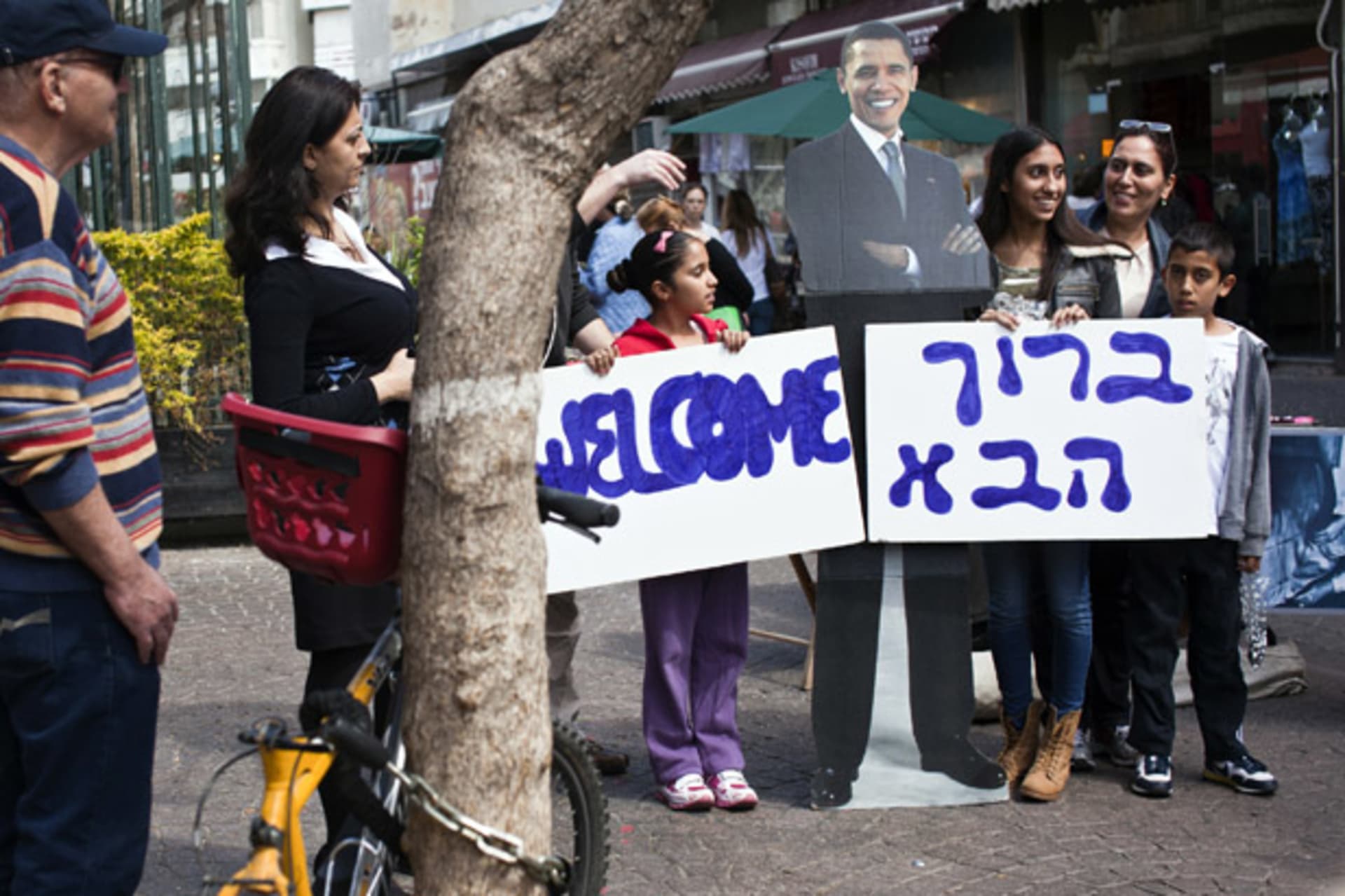 <p>An Israeli family holds welcome signs in Hebrew and English during an event organized by the U.S. embassy in Tel Aviv on March 1, 2013 (Nir Elias/Courtesy Reuters).</p>