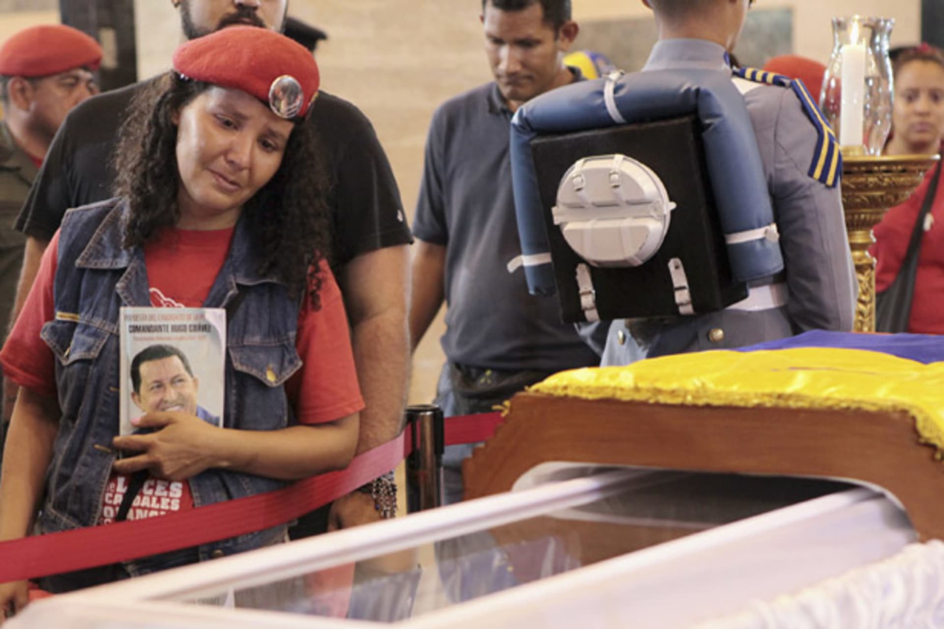 <p>A supporter of the late Venezuelan president Hugo Chavez views his coffin in Caracas (Miraflores Palace Handout/Courtesy Reuters).</p>