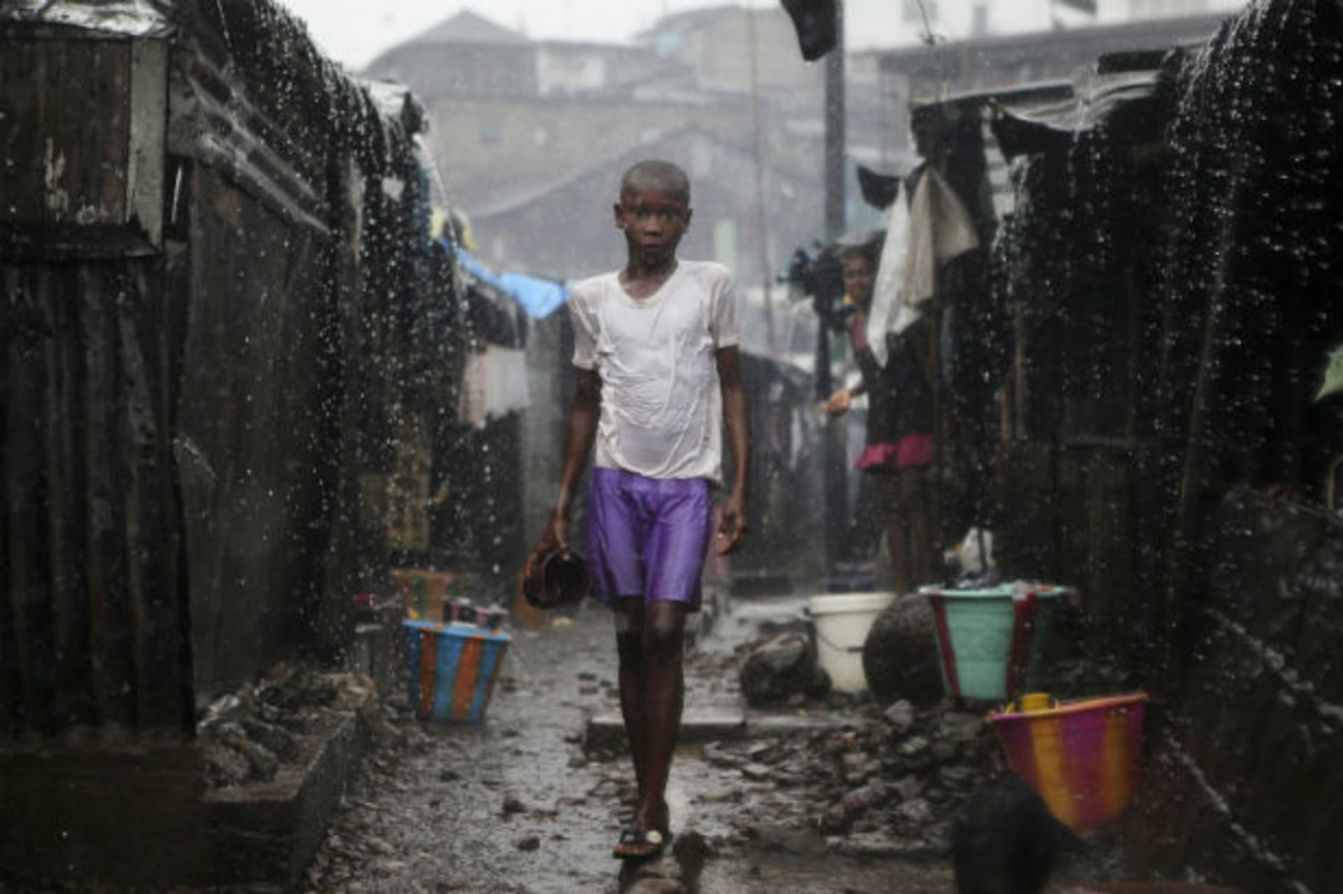 A child stands in pouring rain in the slum of Susan's Bay in Sierra Leone's capital Freetown, August 22, 2012.
