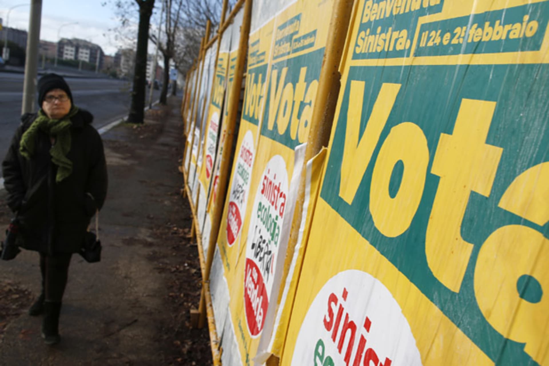 <p>A woman walks past election posters in Rome (Tony Gentile/Courtesy Reuters).</p>
