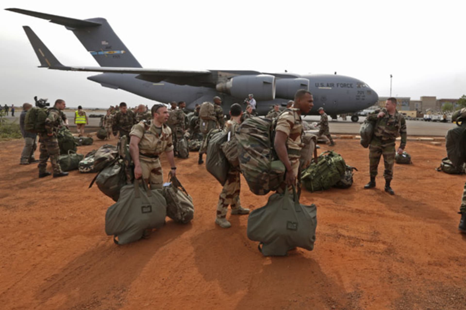 <p>French soldiers carry their equipment after arriving in Bamako, Mali on a U.S. transport plane (Eric Gaillard/Courtesy Reuters).</p>
