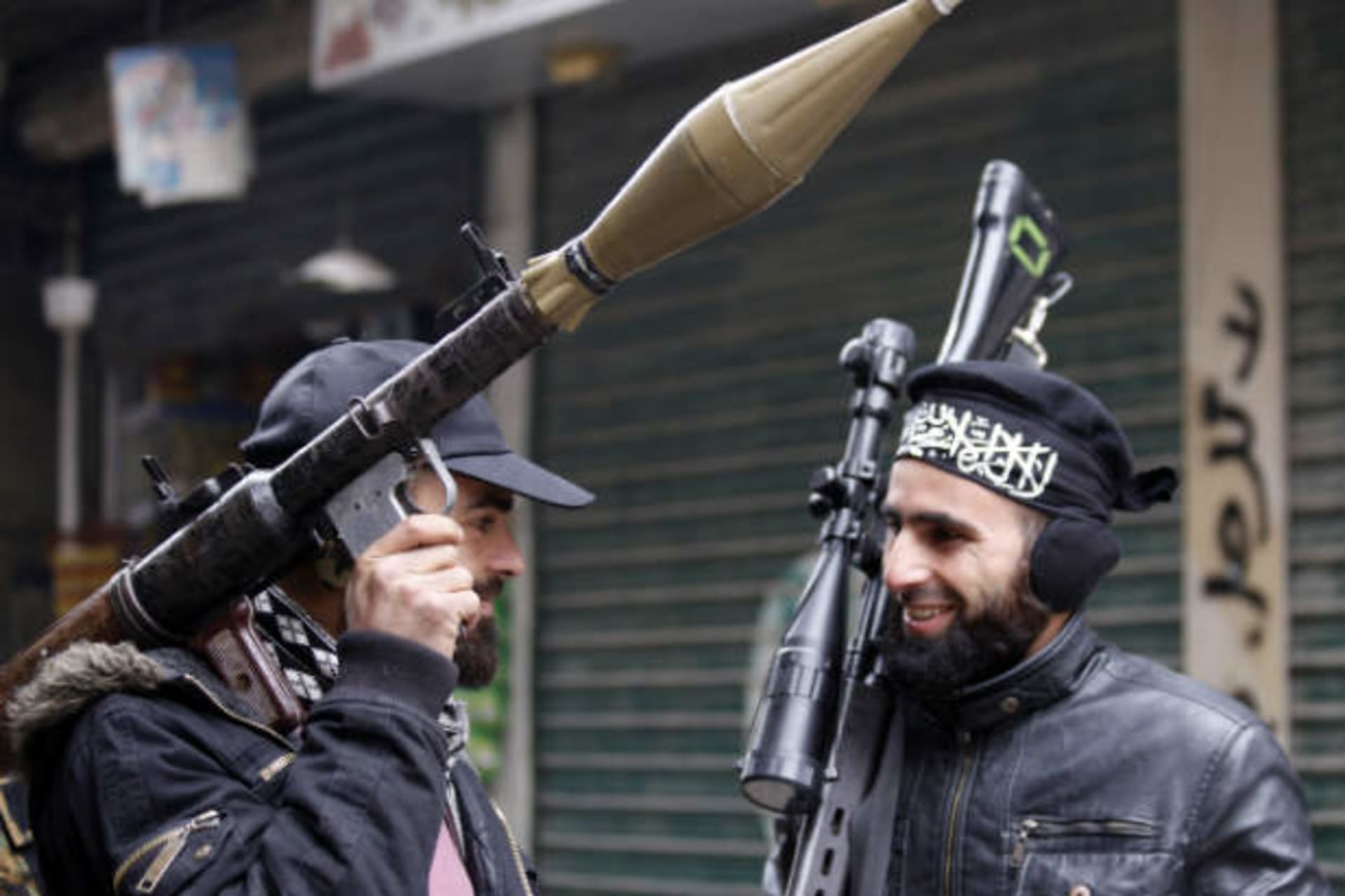 Syrian rebels talk as they carry their weapons before heading to the front line in Aleppo on January 9, 2013 (Karam/Courtesy Reuters).