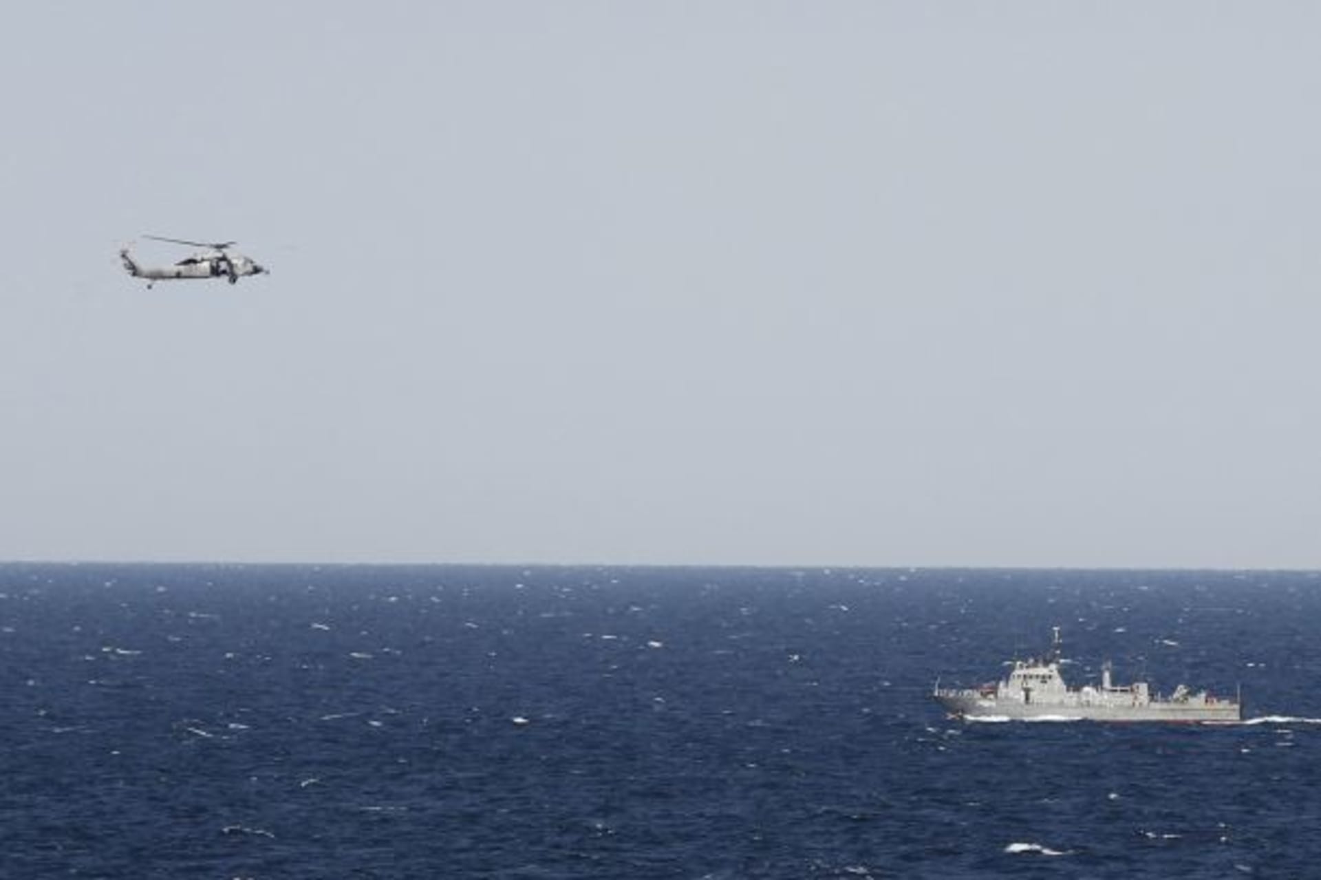 <p>A U.S. helicopter hovers over an Iranian patrol ship in the Strait of Hormuz (Jumana El-Heloueh/Courtesy Reuters).</p>
