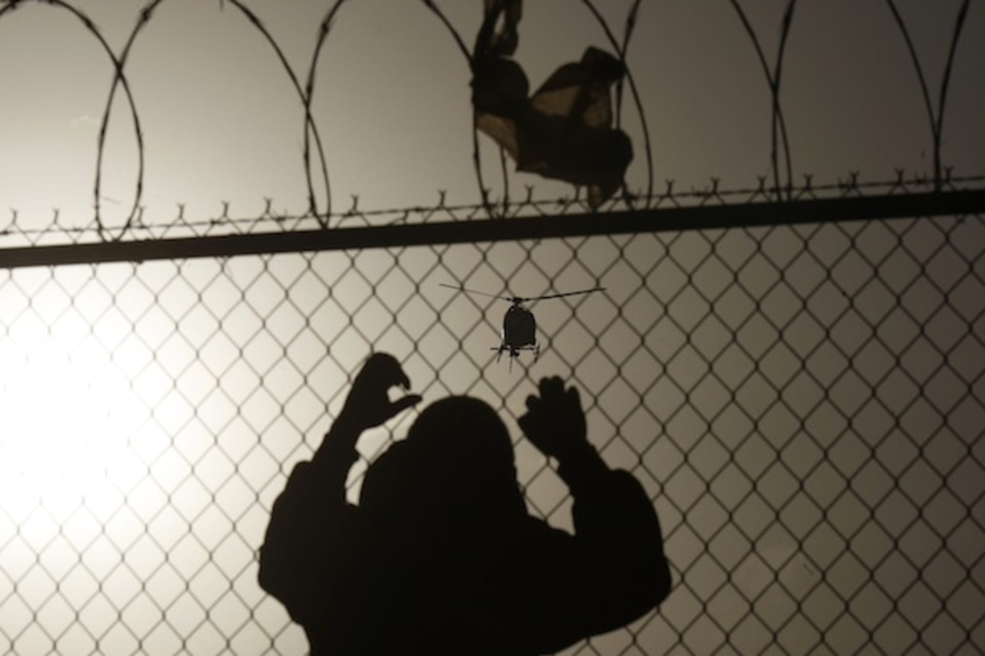<p>A man watches a U.S. border patrol helicopter from a fence at the border in Ciudad Juarez (Stringer Mexico/Courtesy Reuters).</p>
