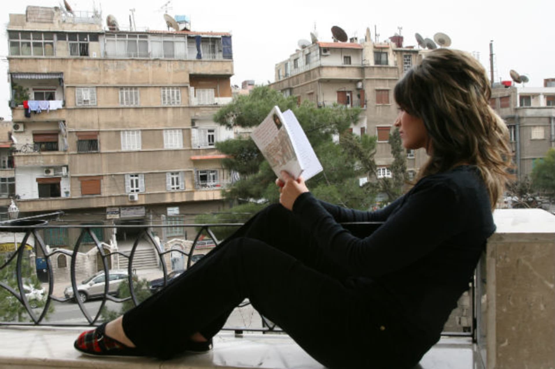 Syrian Bedouin writer and journalist Lina Hawyan al-Hassan, reads a book at her home in Damascus (Khaled Al Hariri / Courtesy Reuters)