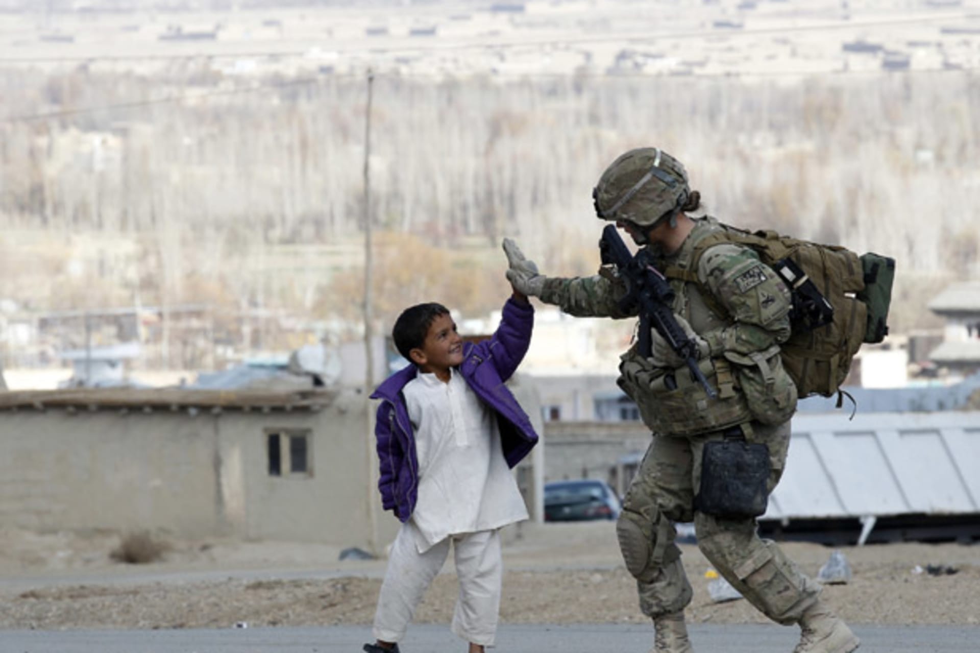 <p>A U.S. Army soldier high-fives with an Afghan boy during a patrol in eastern Afghanistan (Umit Bektas/ Courtesy Reuters).</p>
