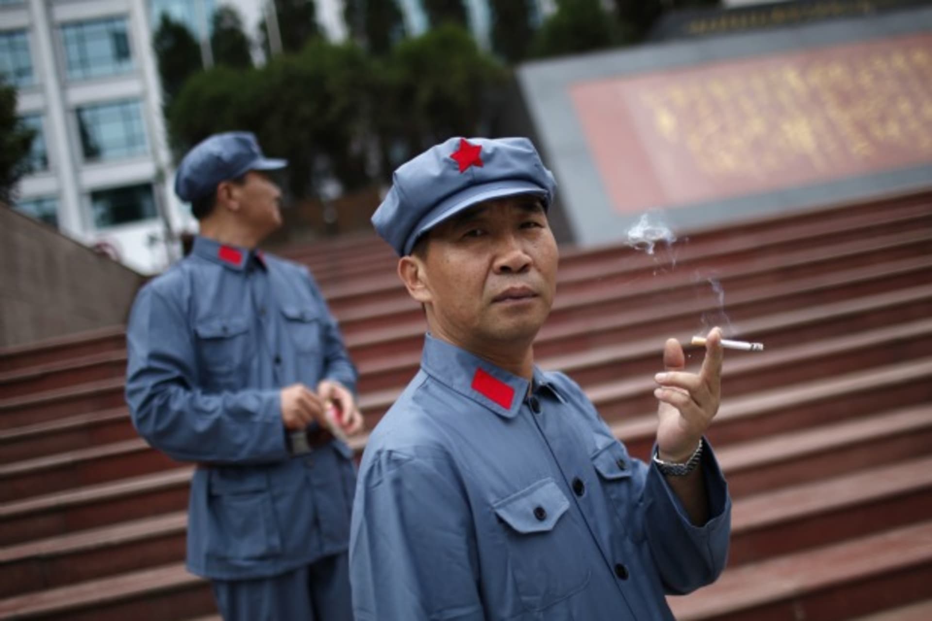 <p>A visitor dressed as a Red Army soldier smokes as he poses for a picture in Jinggangshan, Jiangxi province on September 20, 2012. (Carlos Barria / Courtesy Reuters)</p>
