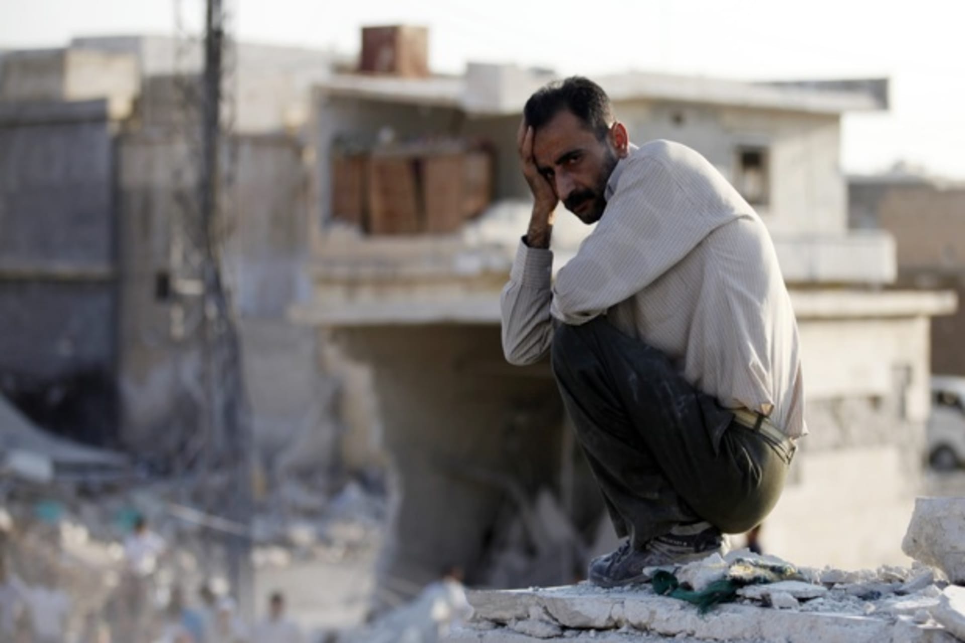 <p>A man sits in front of houses destroyed during a recent air strike in Azaz, Syria (Goran Tomasevic/Courtesy Reuters).</p>

