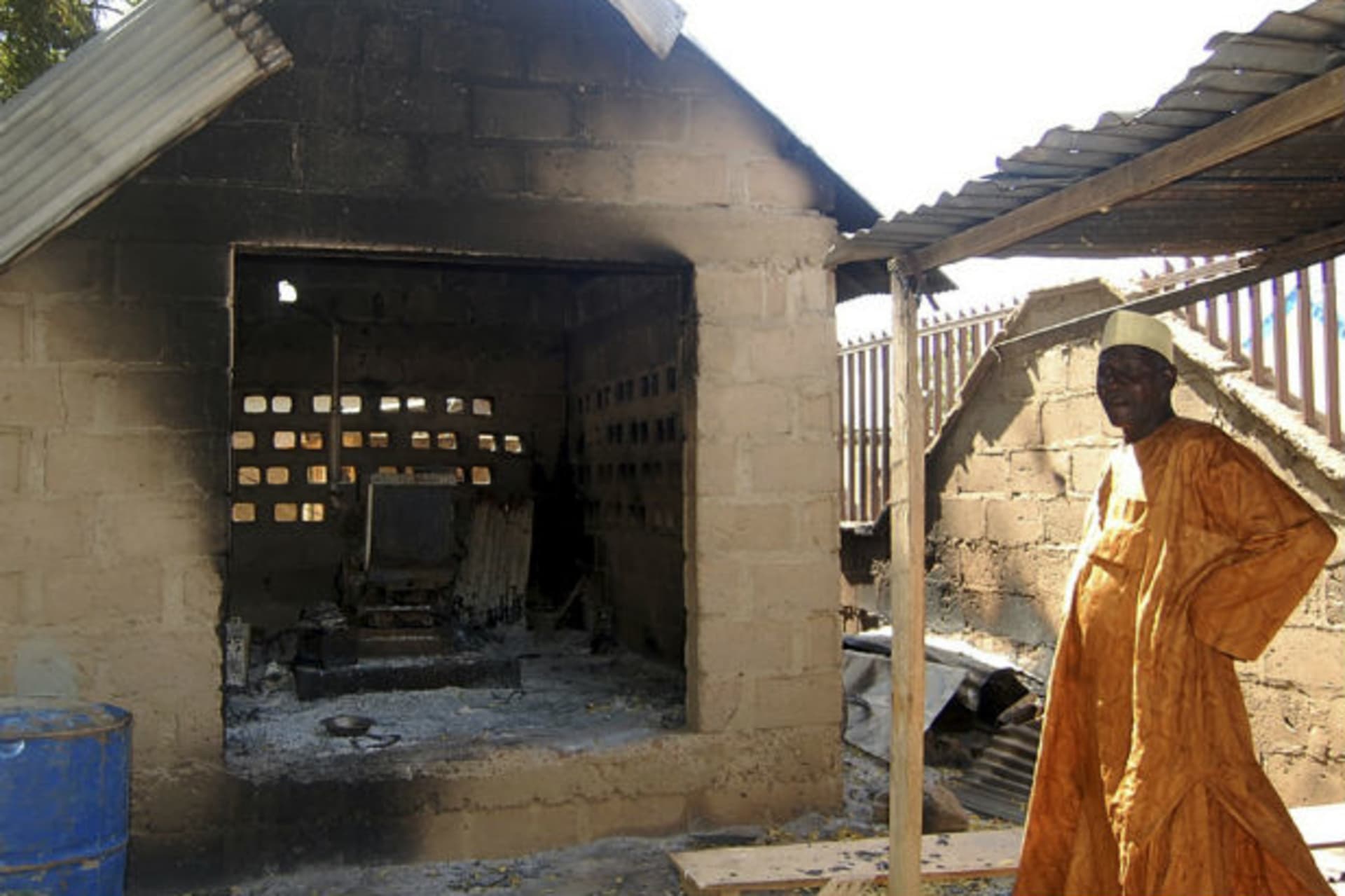 A man stands outside a burnt shed which housed a generator in Damaturu, Yobe state, North east Nigeria, November 8, 2011.