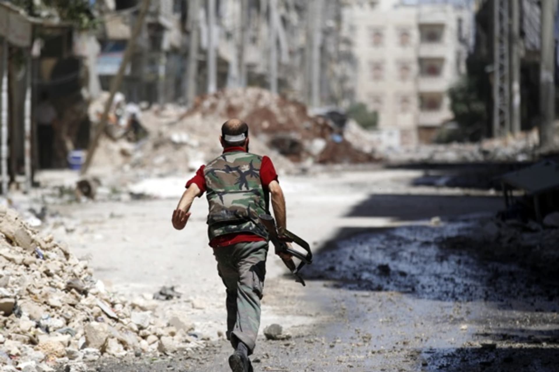 <p>A Free Syrian Army fighter runs during clashes with Syrian army in Aleppo (Goran Tomasevic/Courtesy Reuters).</p>
