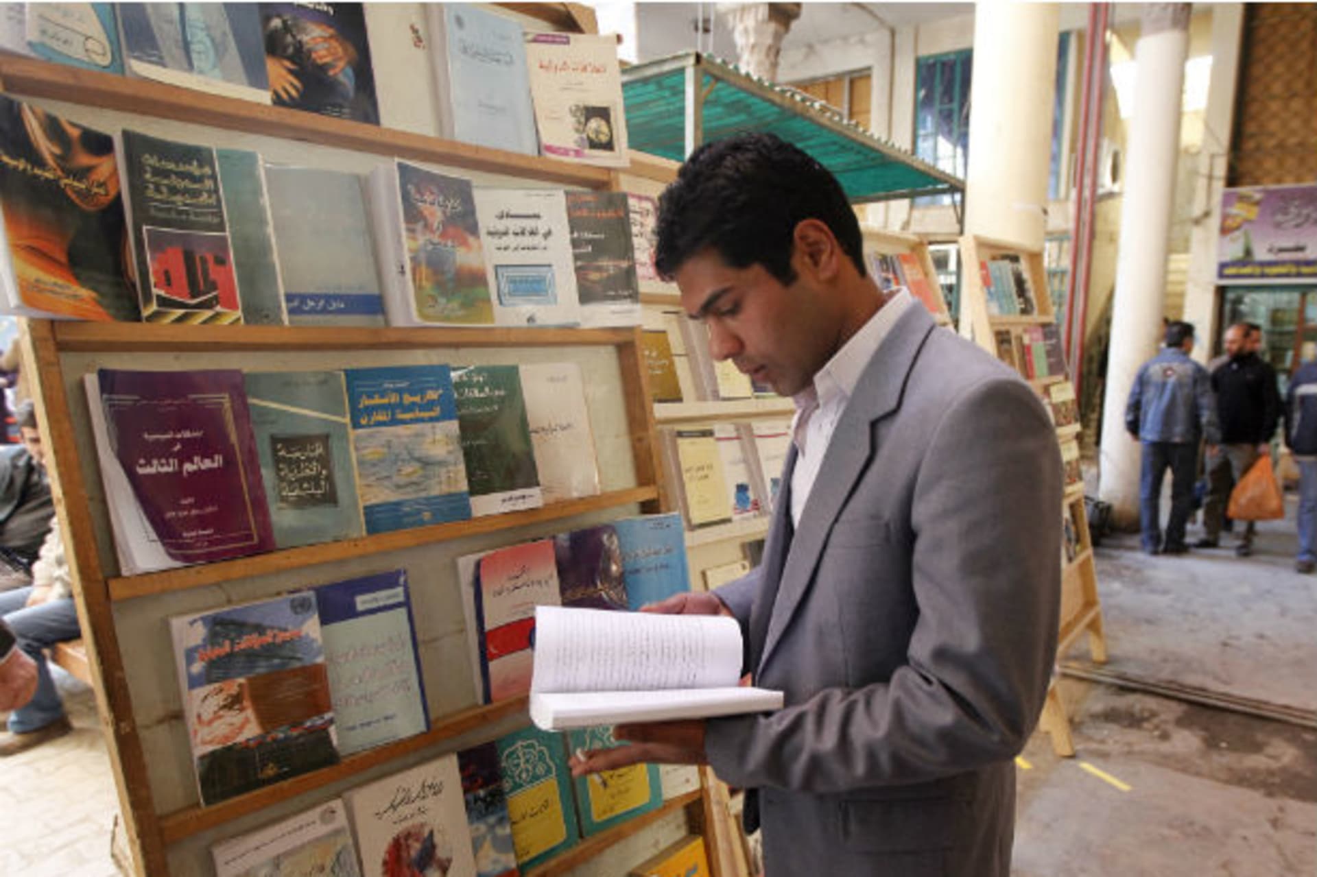 A man reads a book at Mutanabi Street in Baghdad