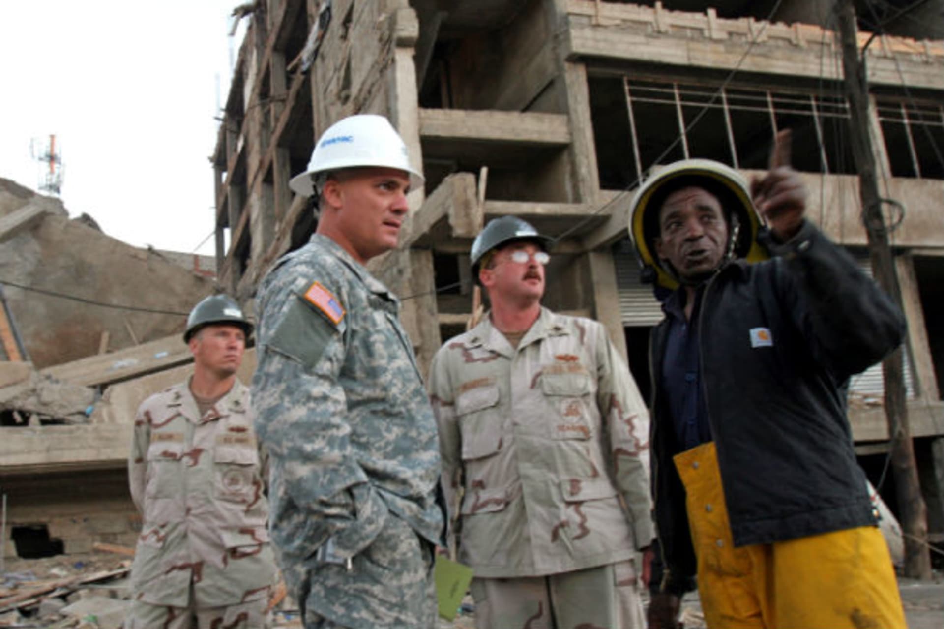 Three U.S. officers of the U.S. joint military effort from the Combined Joint Task Force (CJTF)-Djibouti are introduced to the site by a Kenyan engineer (R) after they arrived at the scene of a collapsed building in Nairobi, Kenya January 24, 2