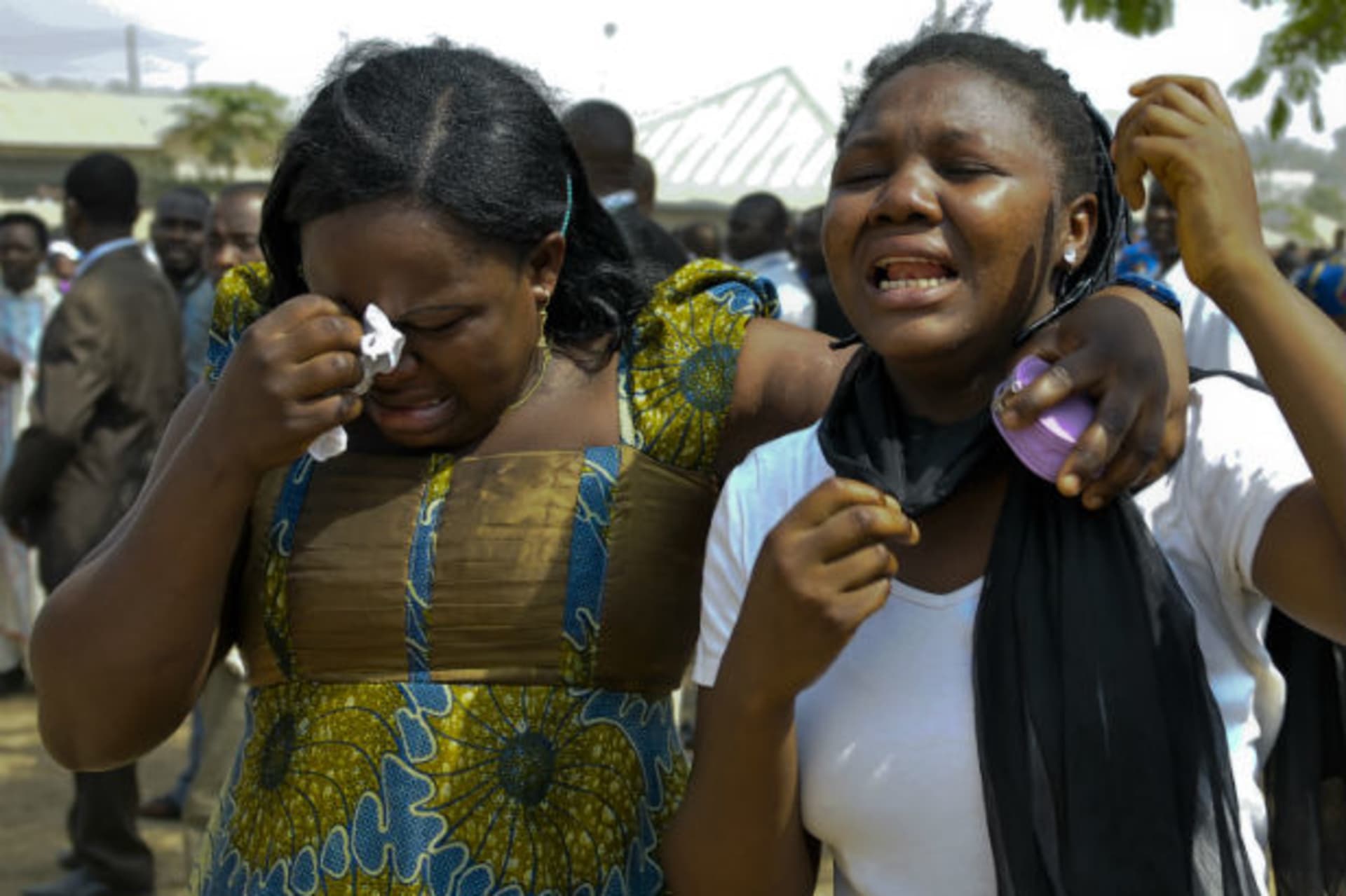 Women cry during a mass funeral for the victims of Christmas day bombing at St Theresa Catholic church, outside Nigeria's capital Abuja February 1, 2012