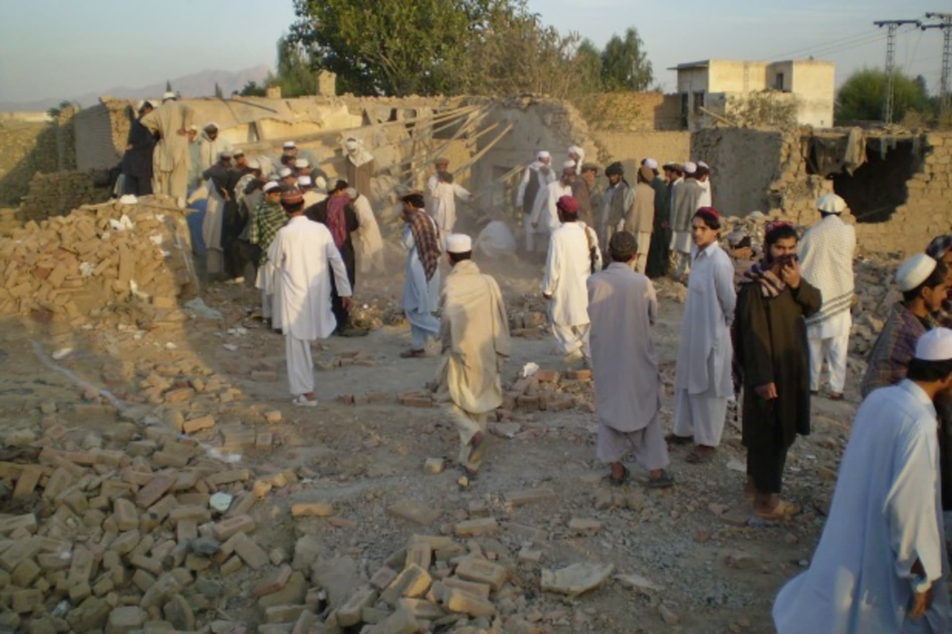 <p>Tribesmen gather at a damaged house struck by a drone missile in northern Waziristan (Stringer Pakistan/Courtesy Reuters).</p>
