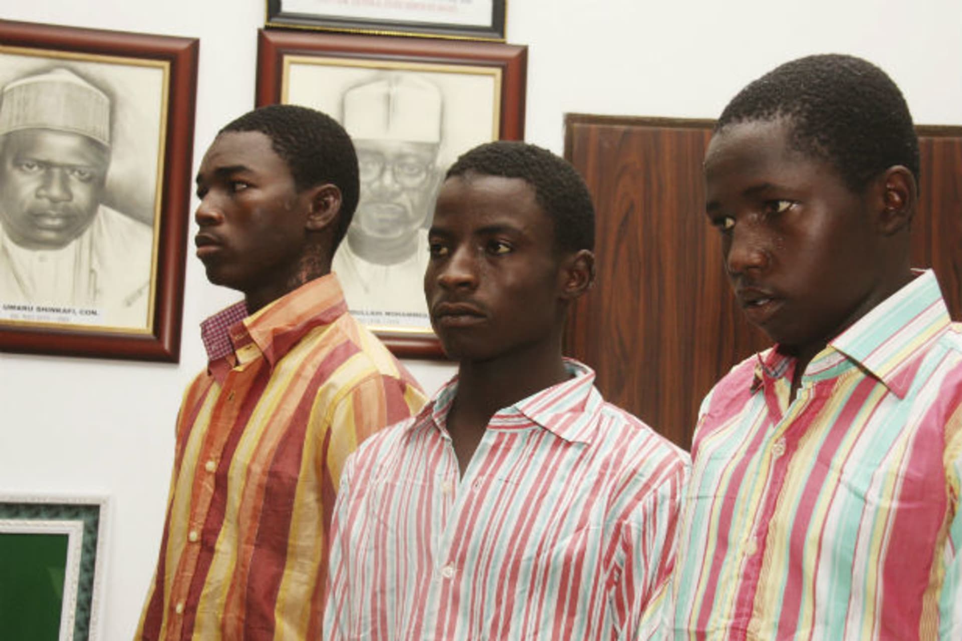 Suspected members of the Abu Mohammed-led faction of the radical Islamic sect Boko Haram , Bashir Ibrhim (L), Ibrahim Habibu (C) and Gambo Maiborodi, are presented to the media while awaiting official charges for alleged involvement in the kidn