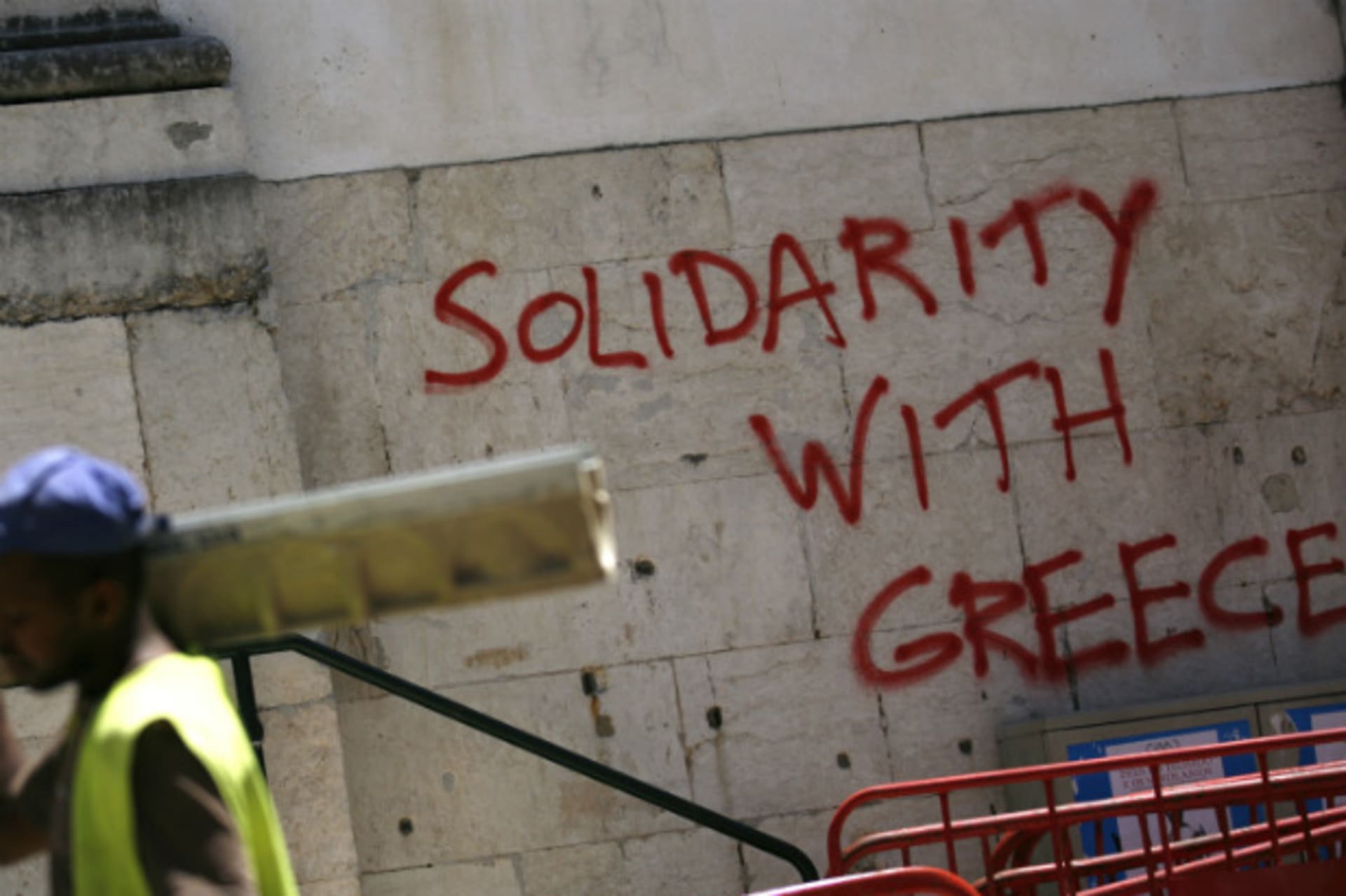 <p>A worker in Lisbon, Portugal passes by some graffiti. (Rafael Marchante/courtesy Reuters)</p>
