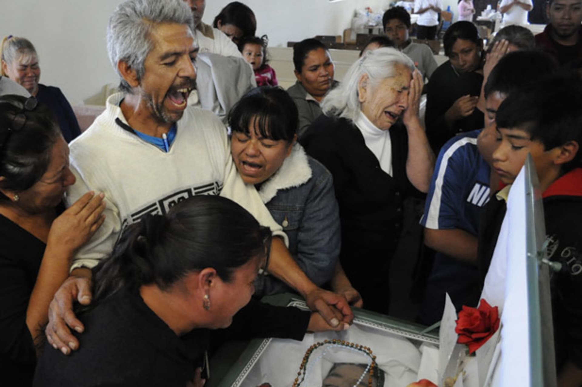A man mourns during the funeral for his two sons who were both killed at a family birthday party, in Ciudad Juarez