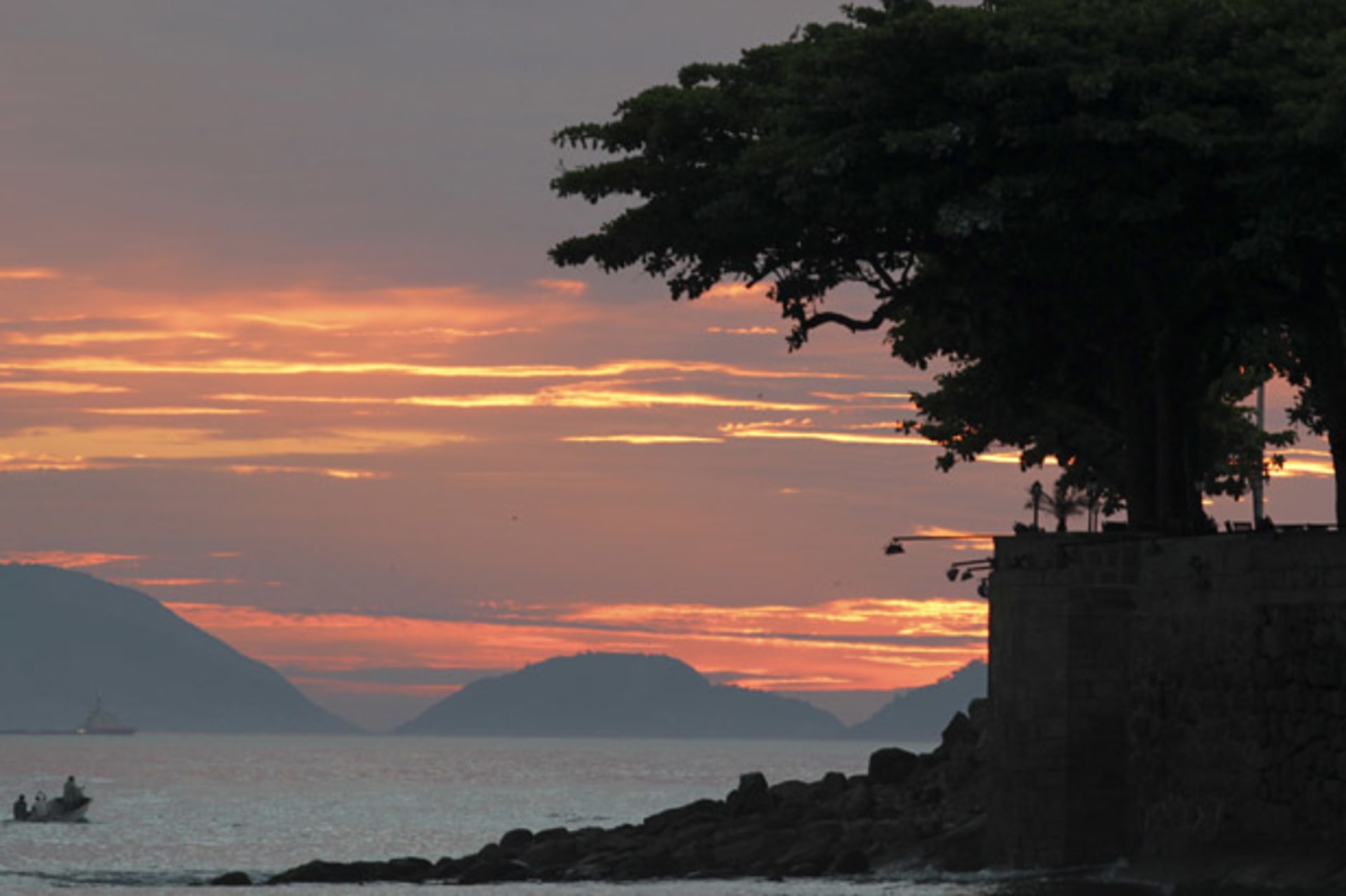 A boat is seen near Copacabana Beach at sunrise in Rio de Janeiro