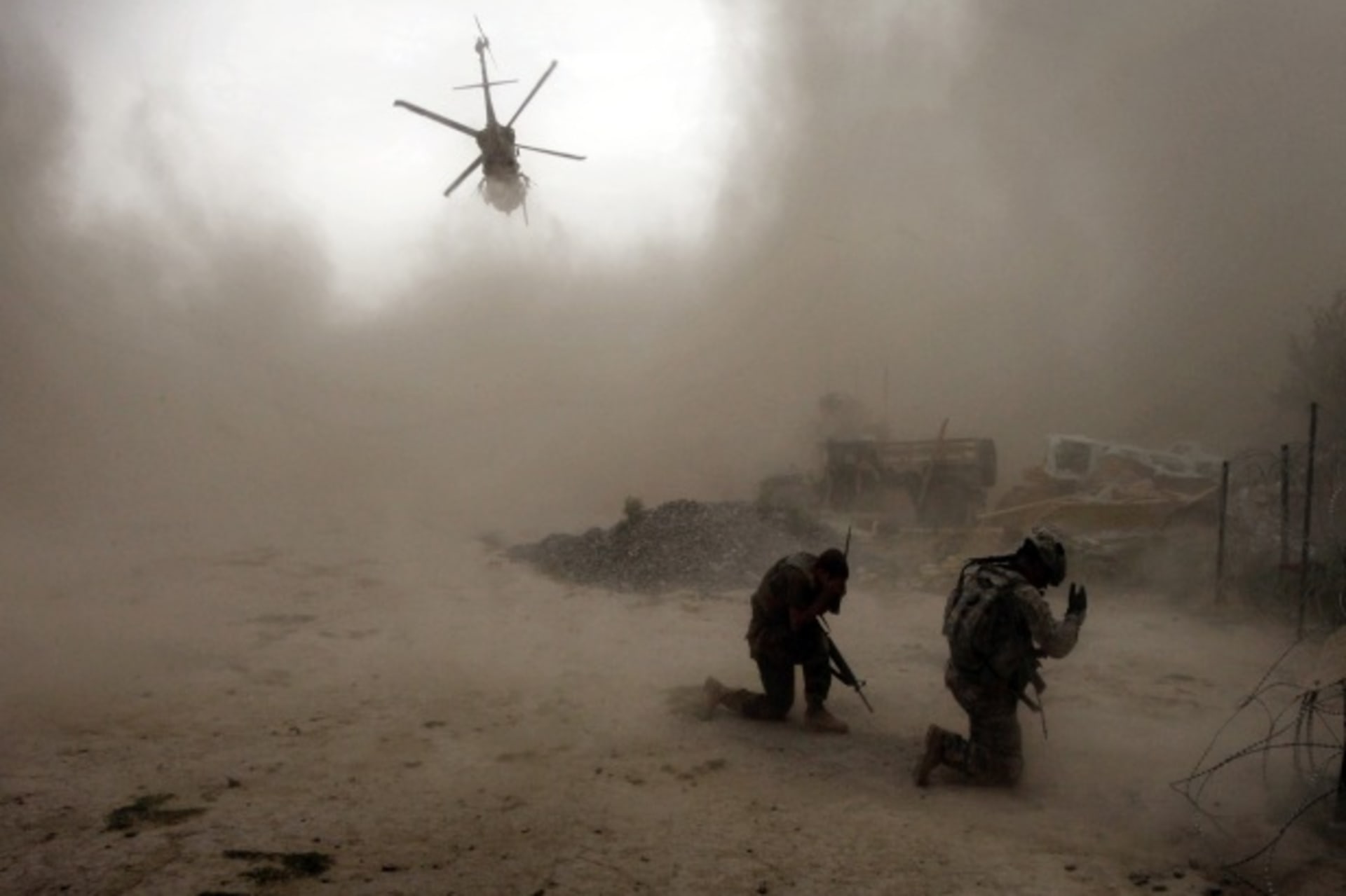 <p>U.S. Army soldiers shield themselves as a Medivac helicopter takes off from Arghandab Valley, Afghanistan (Courtesy Reuters/Bob Strong).</p>
