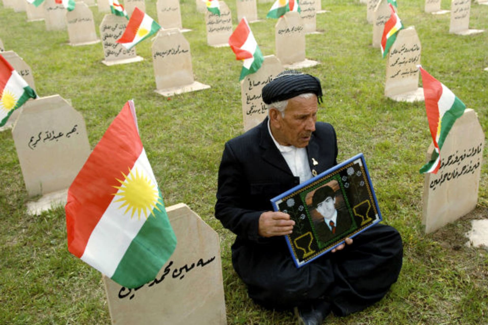 A resident holds a picture of his son at a cemetery for Kurdish poison gas victims in the town of Halabja on March 16, 2010 (Jamal Penjweny/Courtesy Reuters).