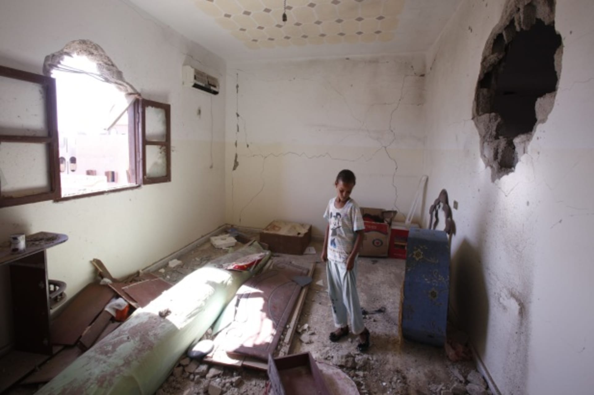 <p>A child stands in her room after her family returned to their home in Sirte, Libya (Courtesy Reuters/Youssef Boudlal).</p>
