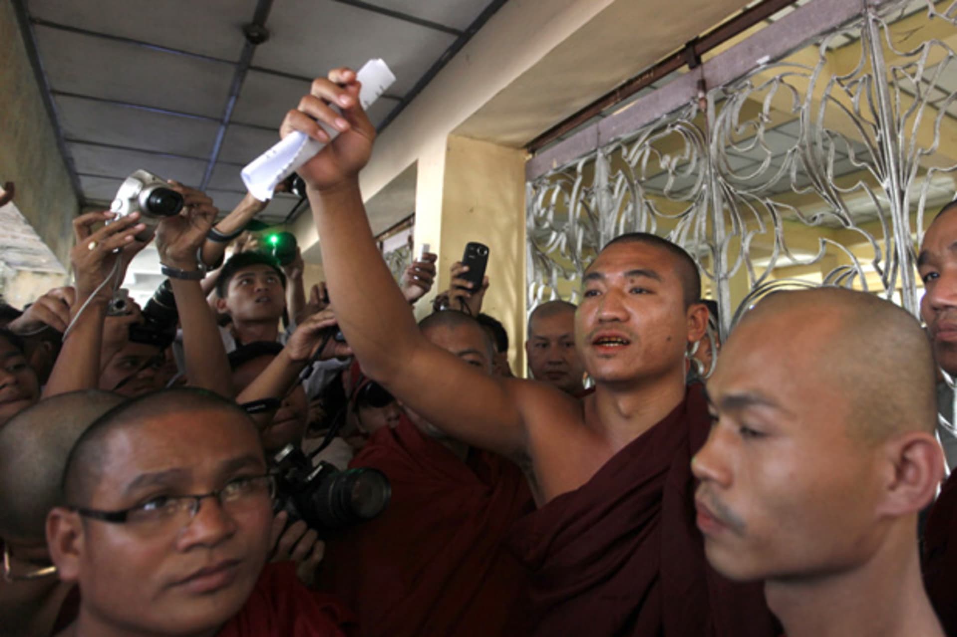 <p>Shin Gambira (center), leader of the All-Burmese Monks Alliance, talks to supporters in January, 2012, after his release from prison. BBC News reported Friday that he has been once again taken away by Burmese authorities. (Soe Zeya Tun/Courtesy Reuters)</p>
