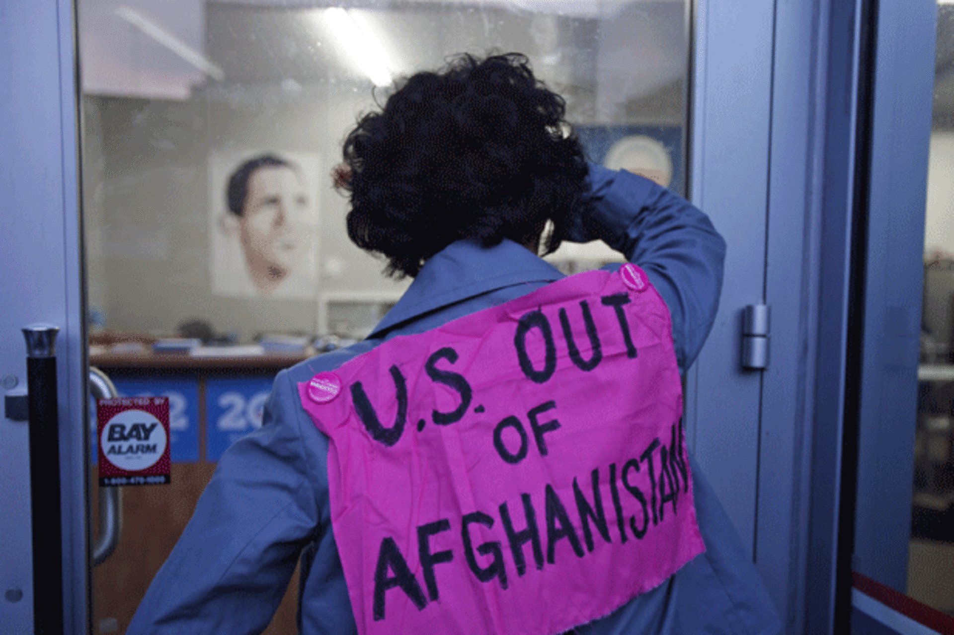 <p>A protester affiliated with the anti-war group Code Pink looks into U.S. President Barack Obama’s campaign headquarters. (Stephen Lam/courtesy Reuters)</p>

