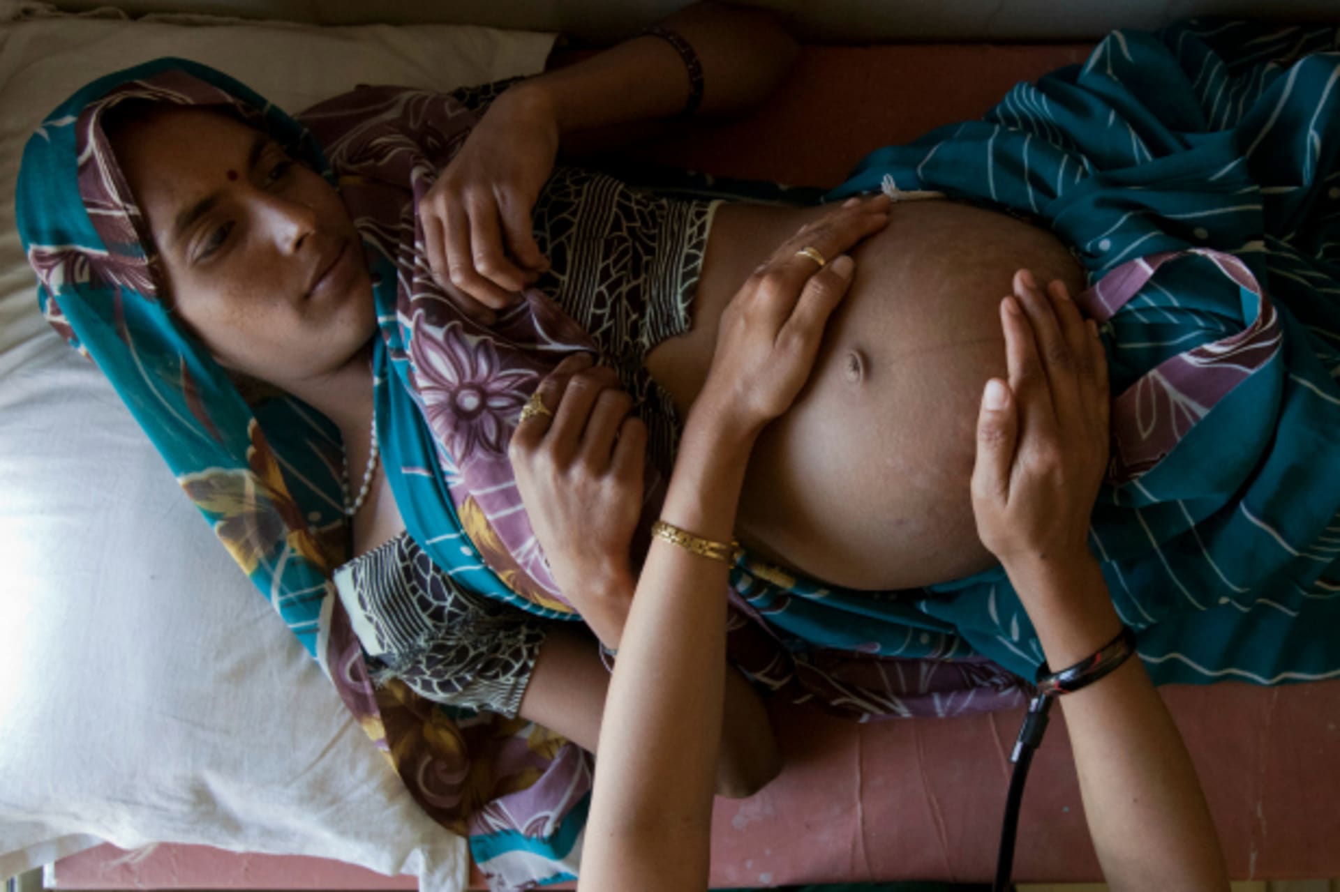 <p>A pregnant woman lies on an examination table during a checkup at a community health center in the remote village of Chharchh, in the central Indian state of Madhya Pradesh, February 2012 (Courtesy Reuters/Vivek Prakash).</p>

