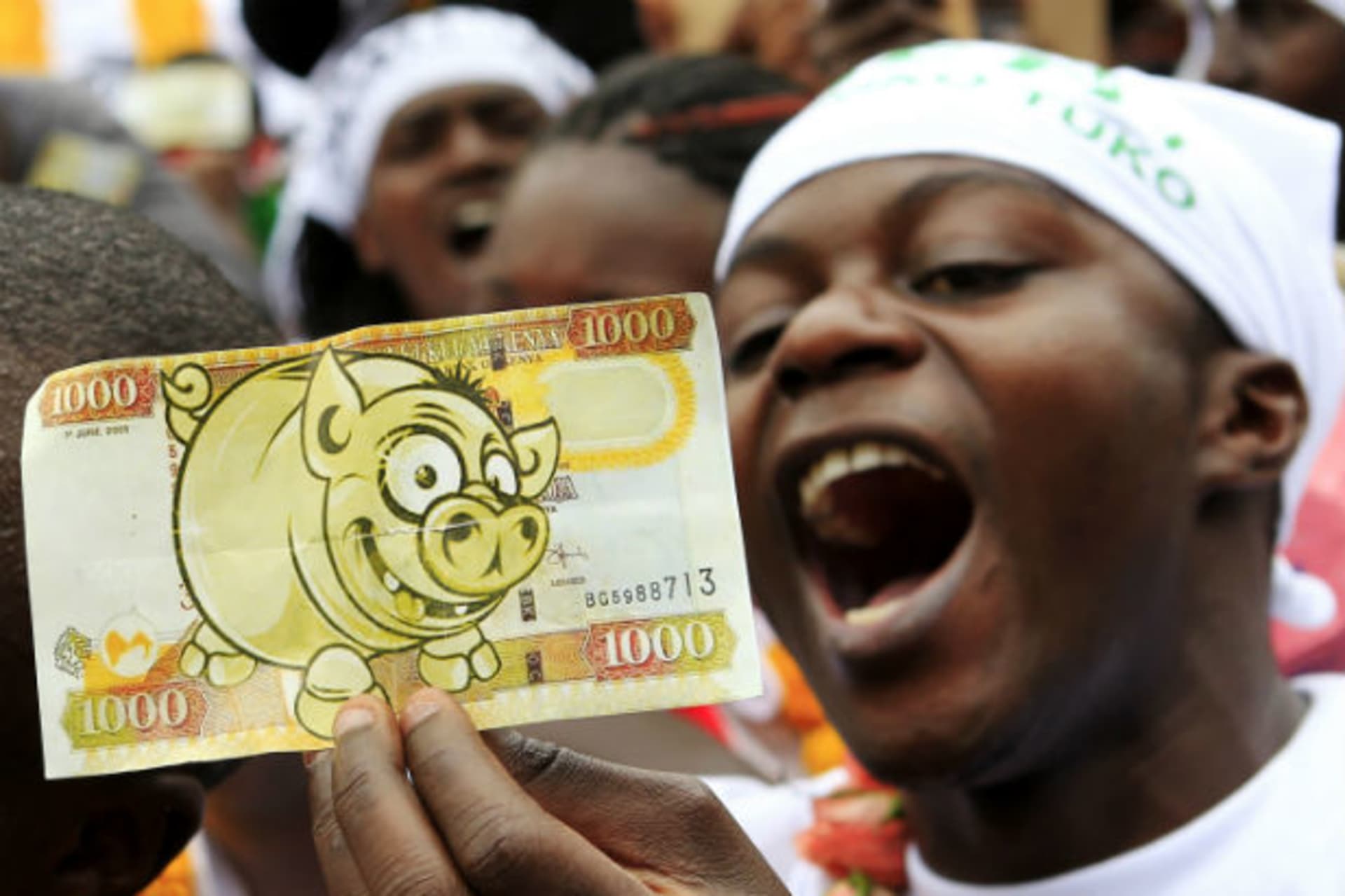 Africa - Guy Holding Fake Kenyan Shilling (Corruption)