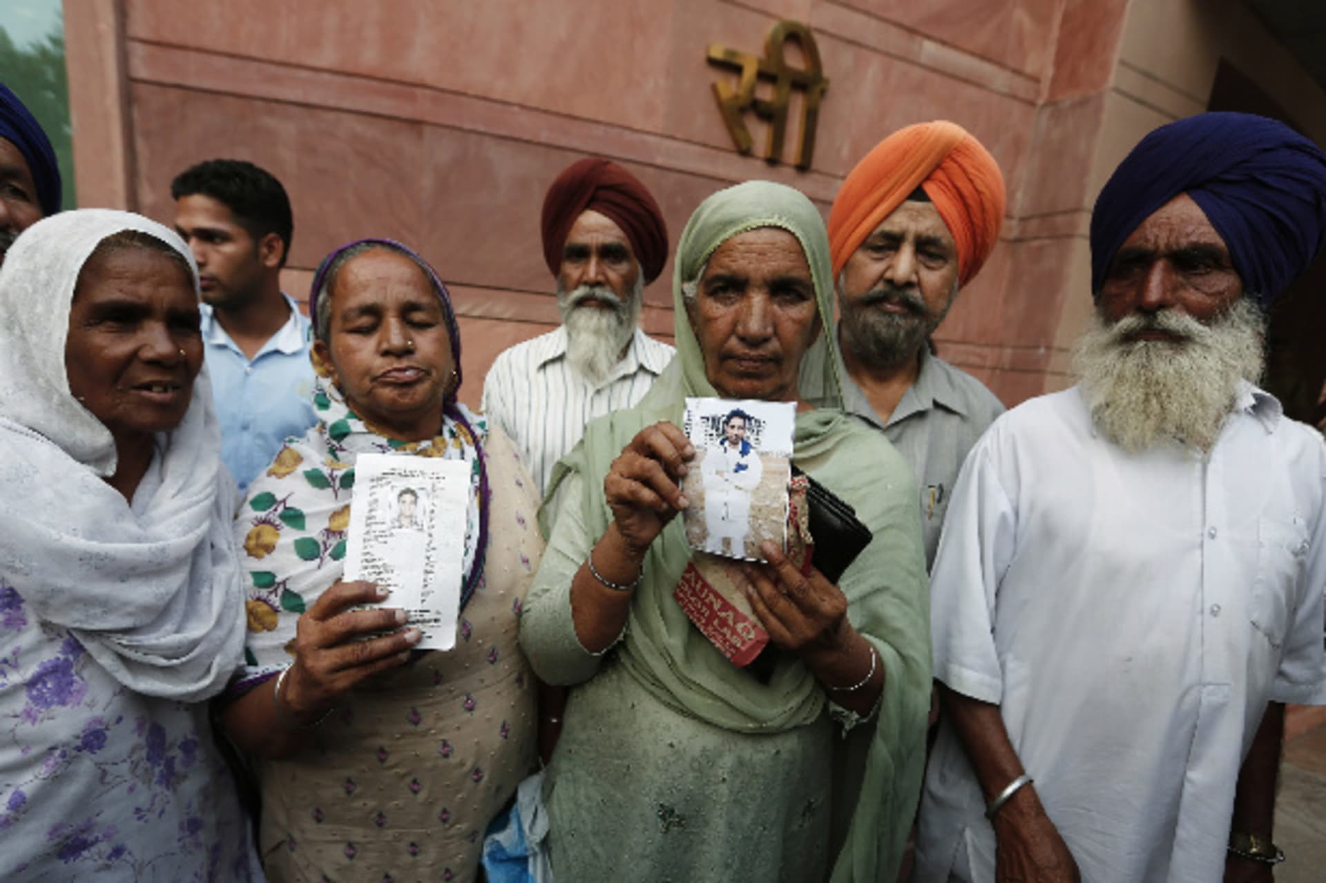 <p>Relatives hold up photographs of Indian workers, who have been kidnapped in Iraq, after their meeting with India’s Foreign Minister Sushma Swaraj in New Delhi on June 19, 2014 (Adnan Abidi/Courtesy: Reuters).</p>
