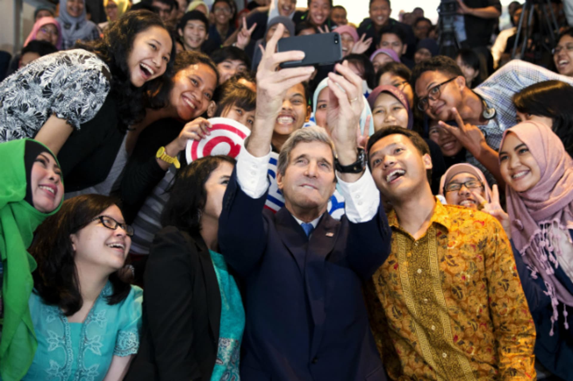 <p>U.S. Secretary of State John Kerry takes a selfie with a group of students before delivering a speech on climate change in Jakarta on February 16, 2014. (Pool New/Courtesy Reuters)</p>
