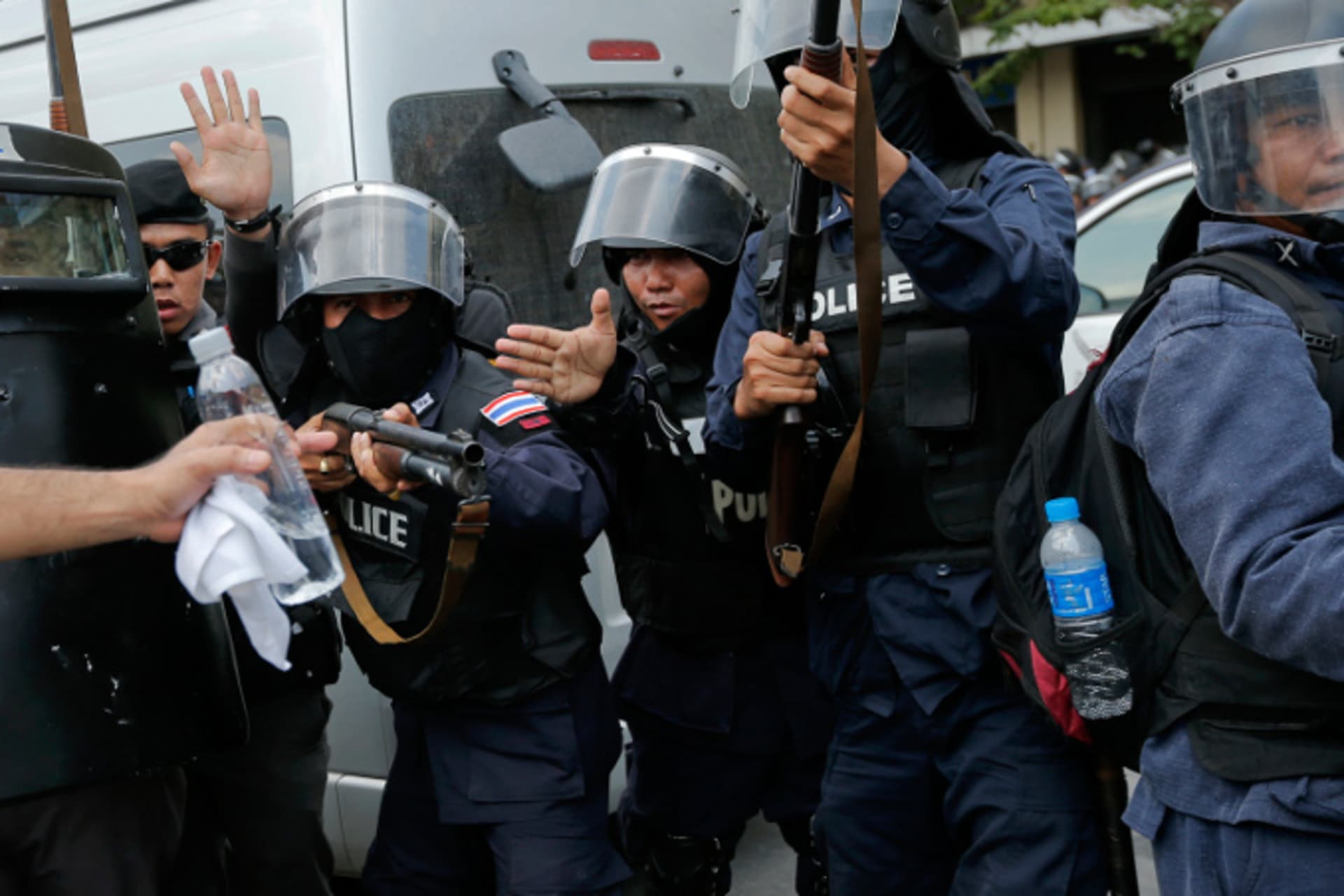 <p>Policemen hold their weapons ready as they pull back during clashes with anti-government protesters near the Government House in Bangkok on February 18, 2014. (Damir Sagolj/Courtesy Reuters)</p>
