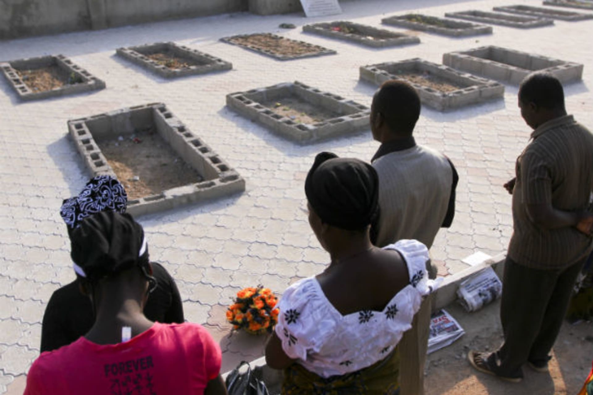 People pray near the graves of victims of a suicide bomb attack during a memorial service at St. Theresa's Church in Madalla, on the outskirts of Nigeria's capital Abuja, December 23, 2012.